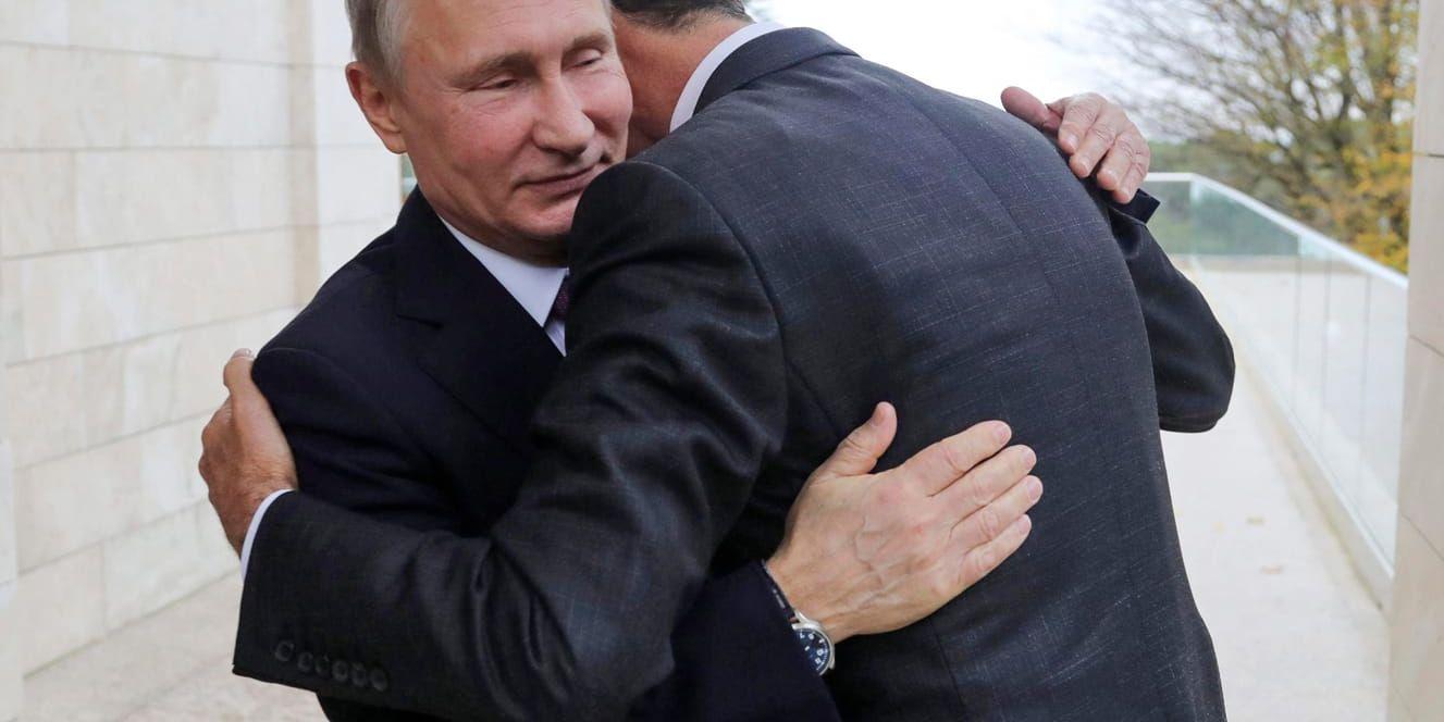 Rysslands president Vladimir Putin omfamnar Syriens president Bashar al-Assad. Arkivbild.