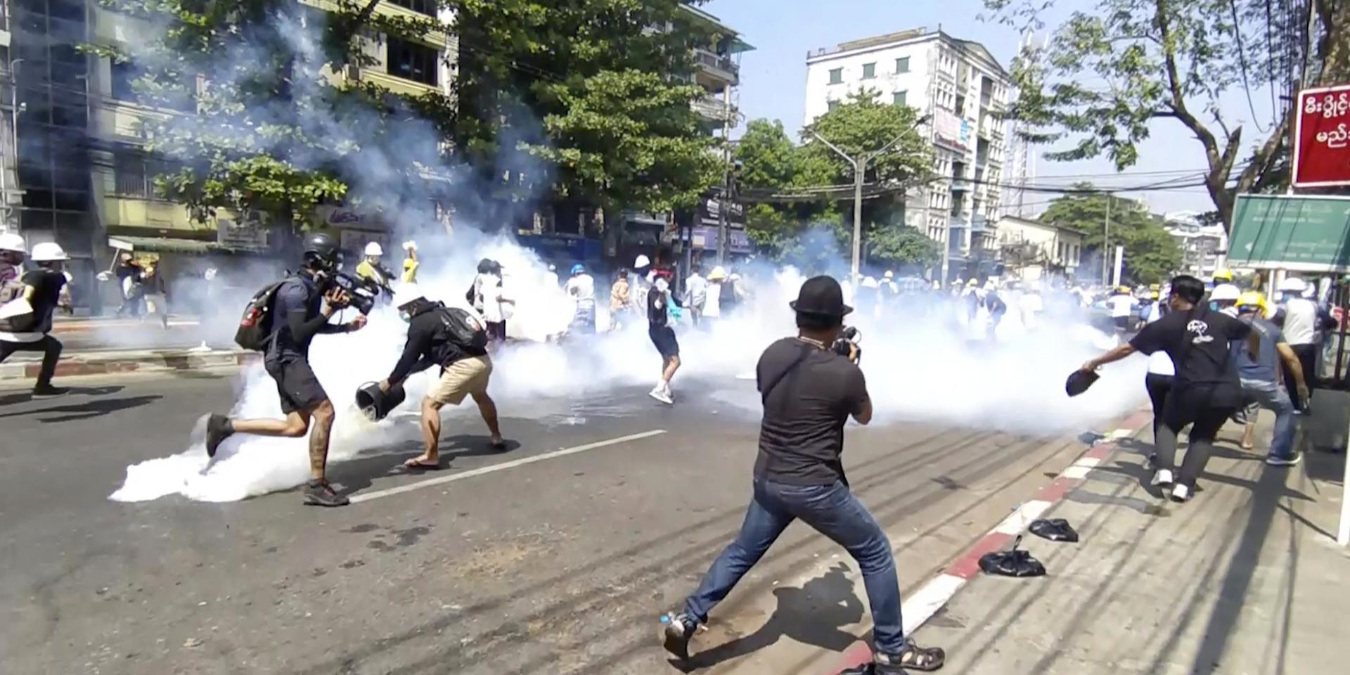Polis i Rangoon använder tårgas mot demonstranter på måndagen.