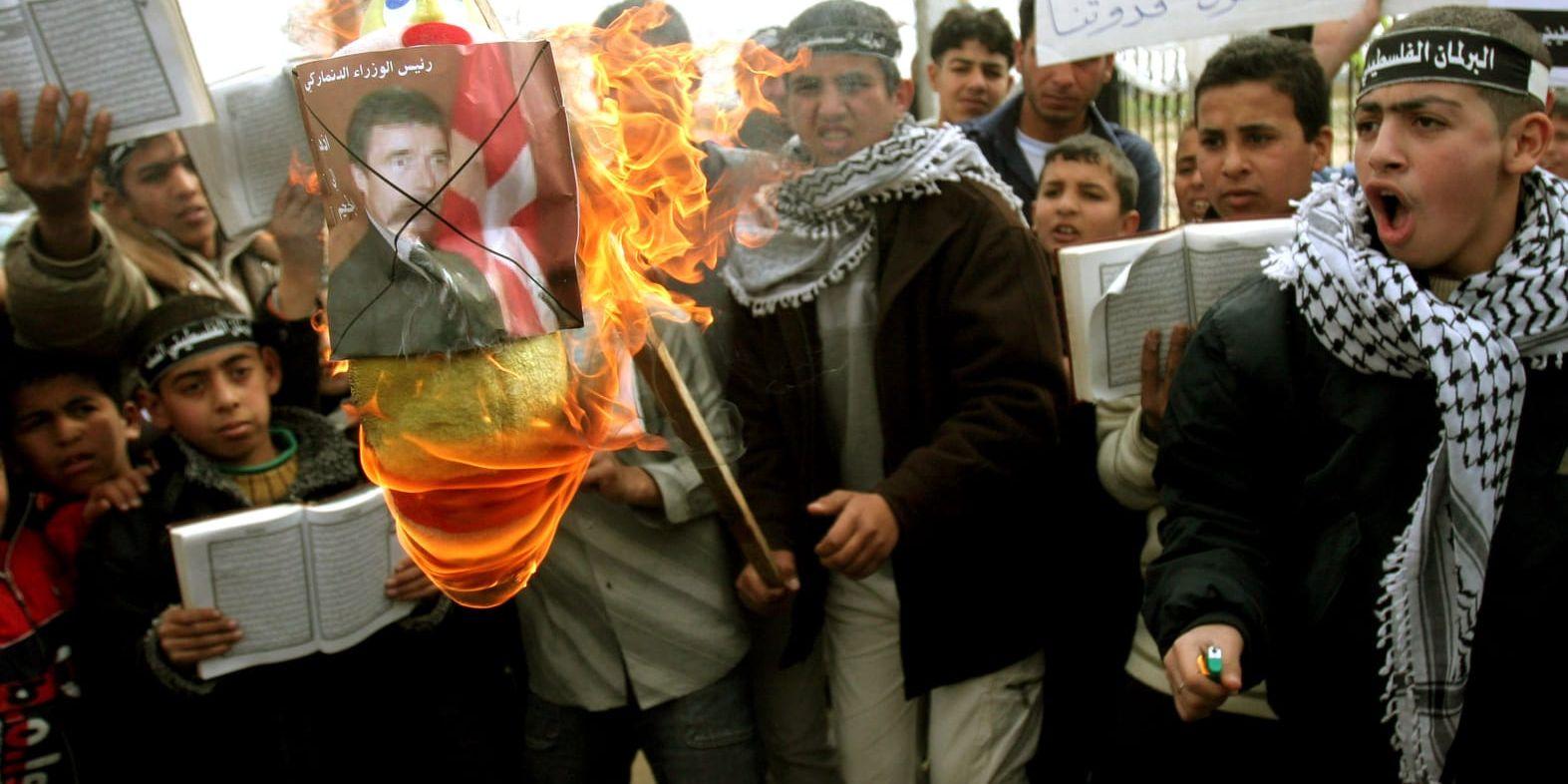 Palestinska barn och ungdomar sätter eld på en bild av Danmarks dåvarande statsminister Anders Fogh Rasmussen i Gaza den 13 februari 2006. Arkivbild.