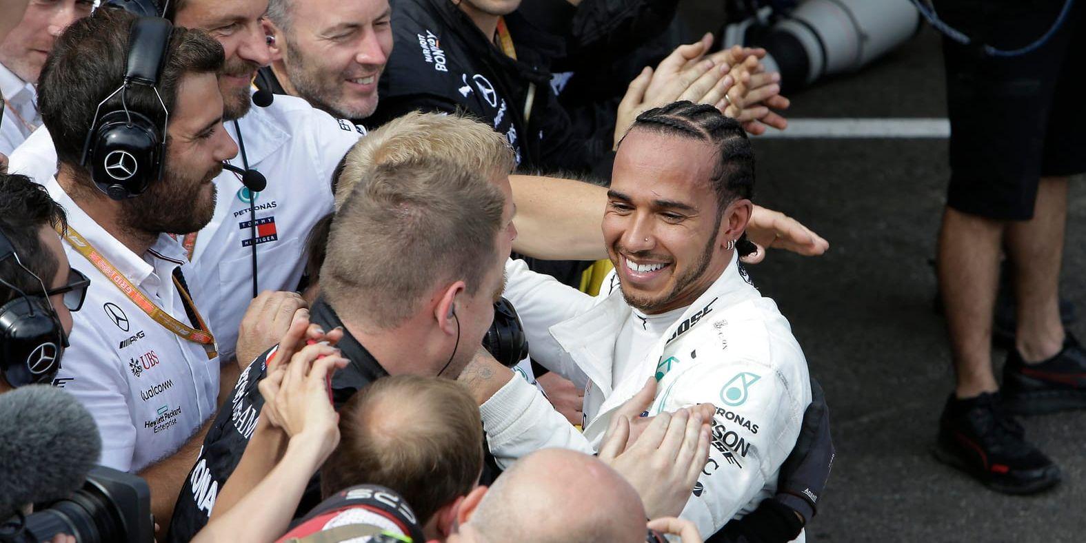 Lewis Hamilton jublar med sitt stall efter segern.
