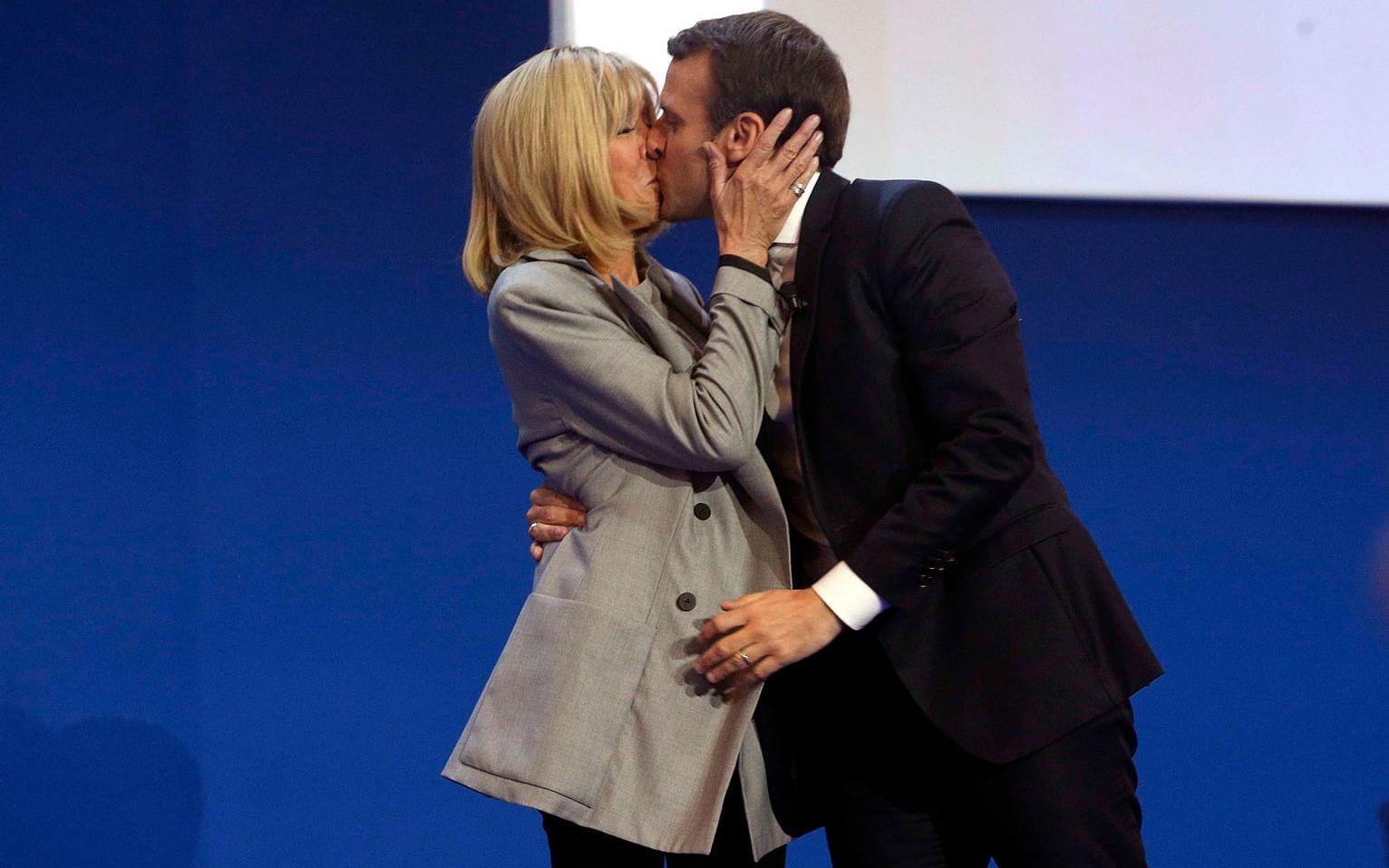 Macron försäkrade i sitt tal att han kommer att vinna andra valomgången – och passade på att ge sin fru Brigitte en kyss. Bild: TT
