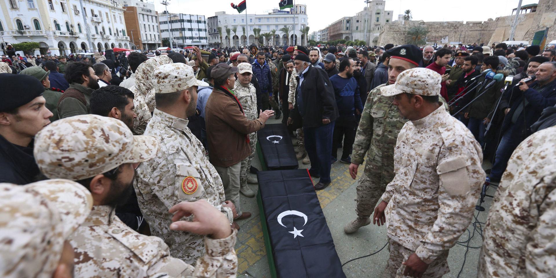 Soldater står vid kistorna i samband med begravningen av några av de kadetter som dödades i en attack i Tripoli tidigare i år. Arkivbild. 