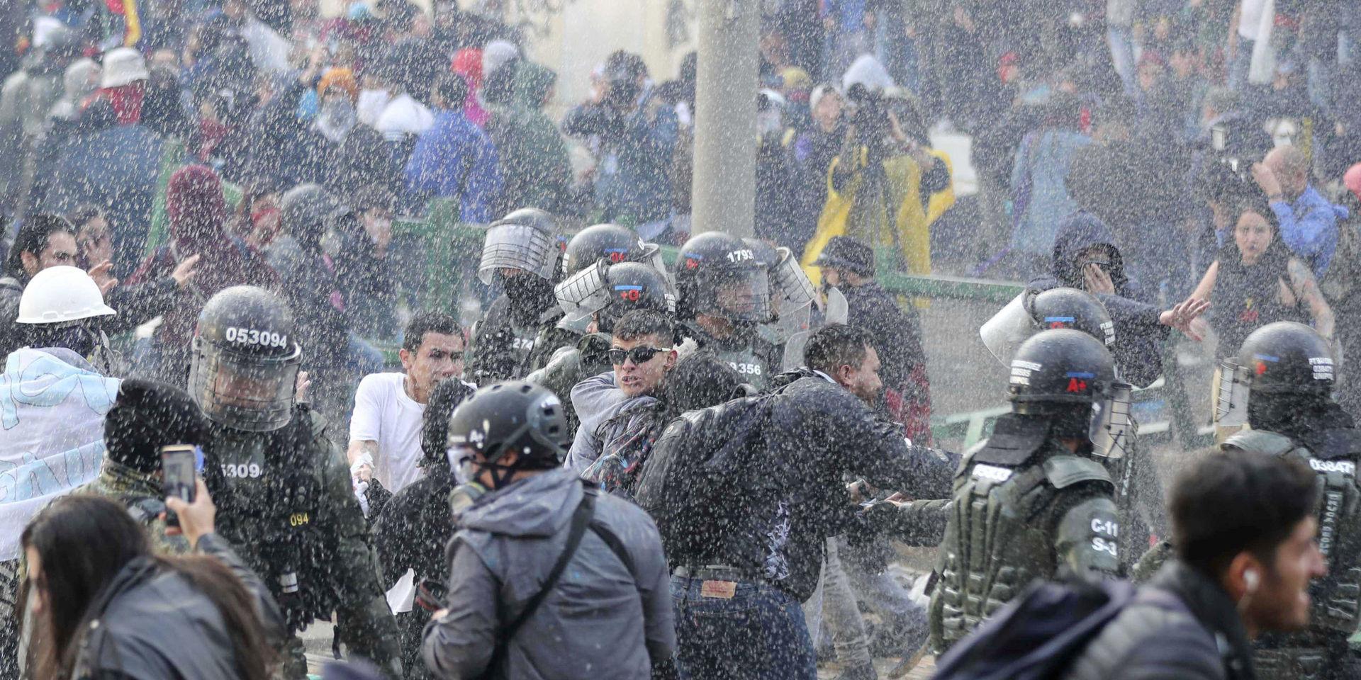 Polisen skingrar demonstranter i centrala Bogotá.