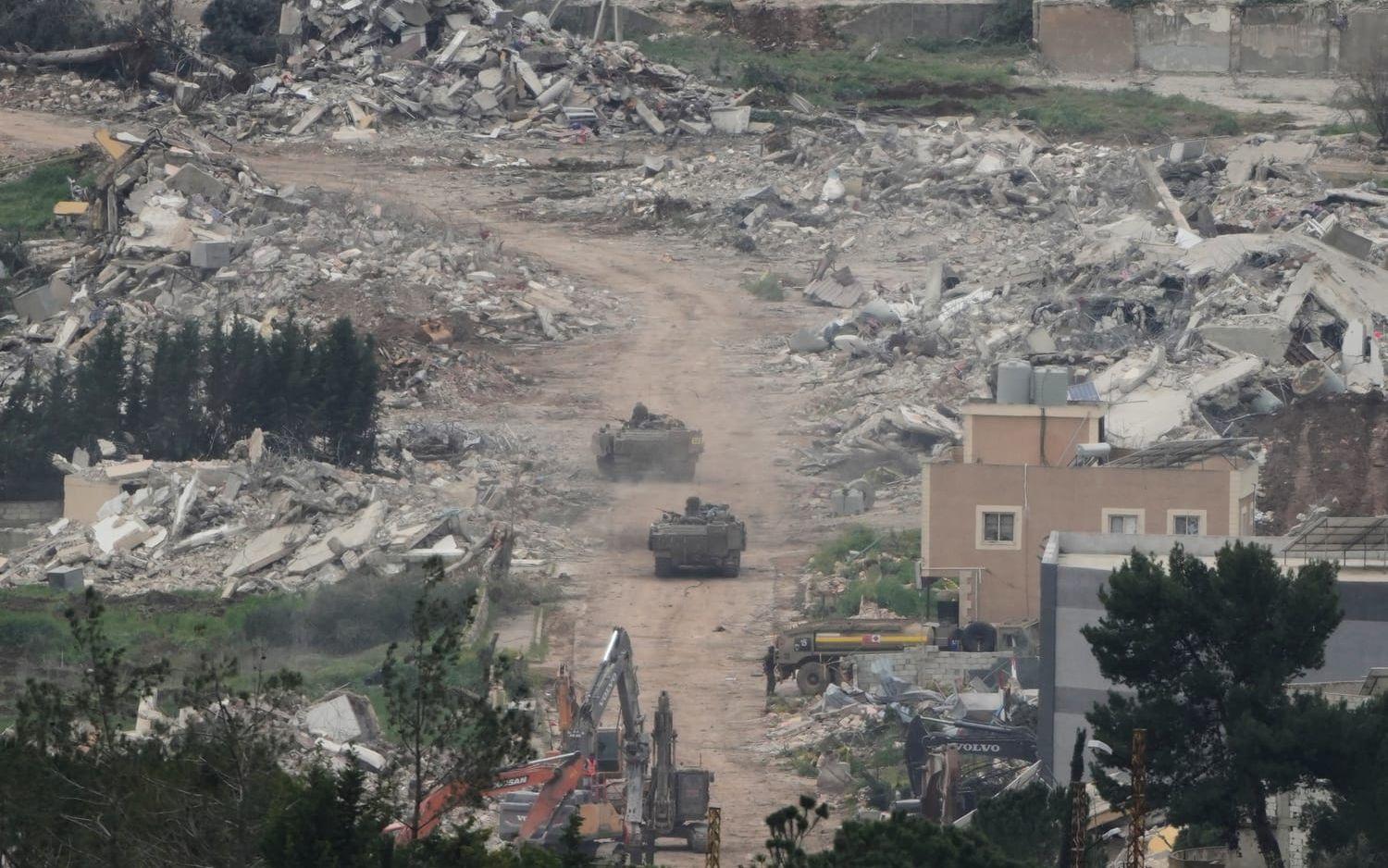 Israeliska militärfordon och bulldozrar bland rasmassor i ett förstört samhälle i södra Libanon. Bilden togs på onsdagen, av en fotograf med utsikt från norra Israel.