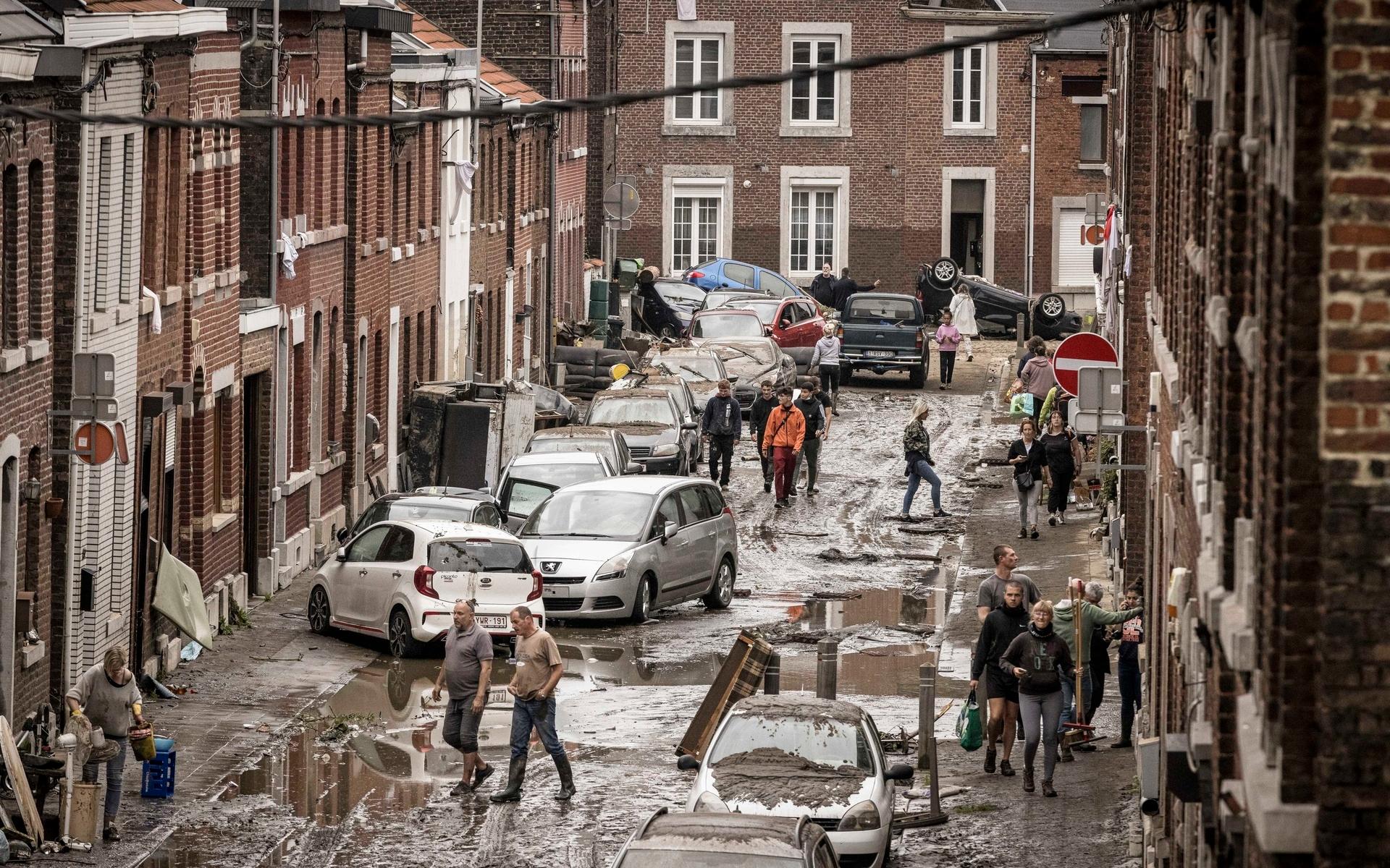 Människor vandra genom en förstörd gata i Chene, Belgien efter översvämningarna efter stormen Bernd i juli i år. 