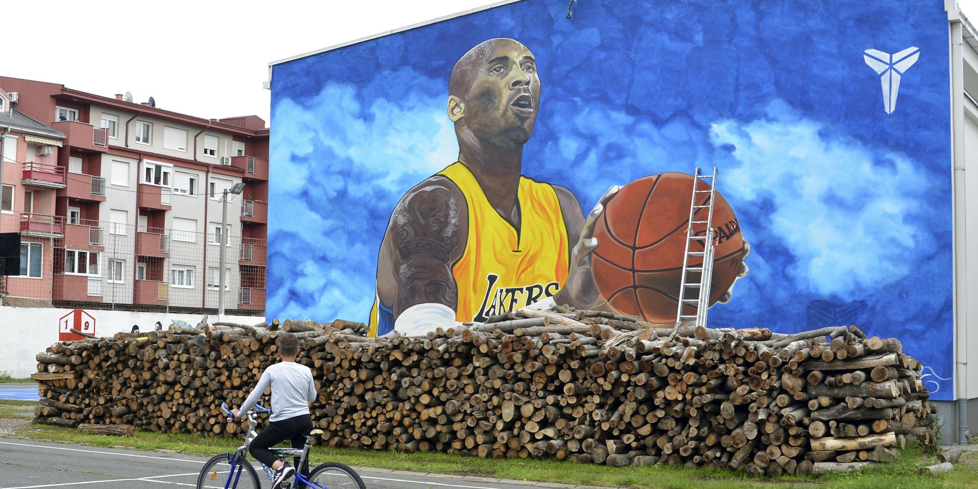 En cyklist betraktar den stora väggmålningen av basketlegenden Kobe Bryant i Bosanska Gradiska i Bosnien-Hercegovina.