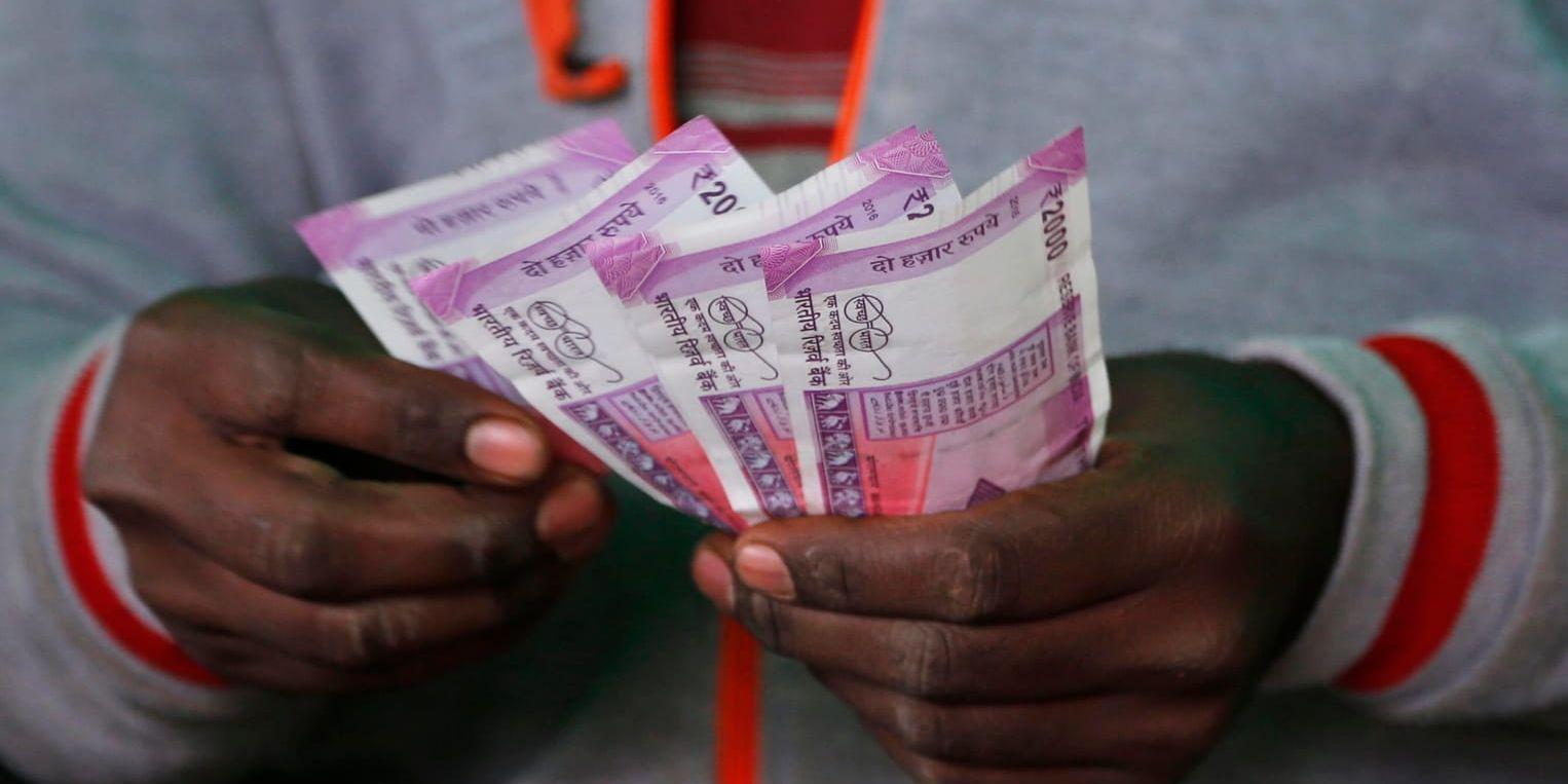 En man i den indiska mångmiljonstaden Bangalore räknar pengar. Det indiska valet beräknas bli det dyraste som världen skådat hittills. Arkivbild.