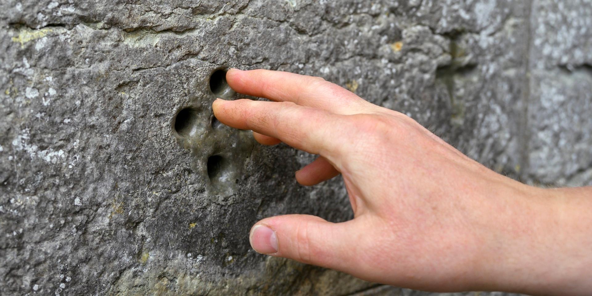Den fem hålen i klosterkyrkans vägg symboliserar Jesu sår. Där ska pilgrimerna stoppa in fingrarna.