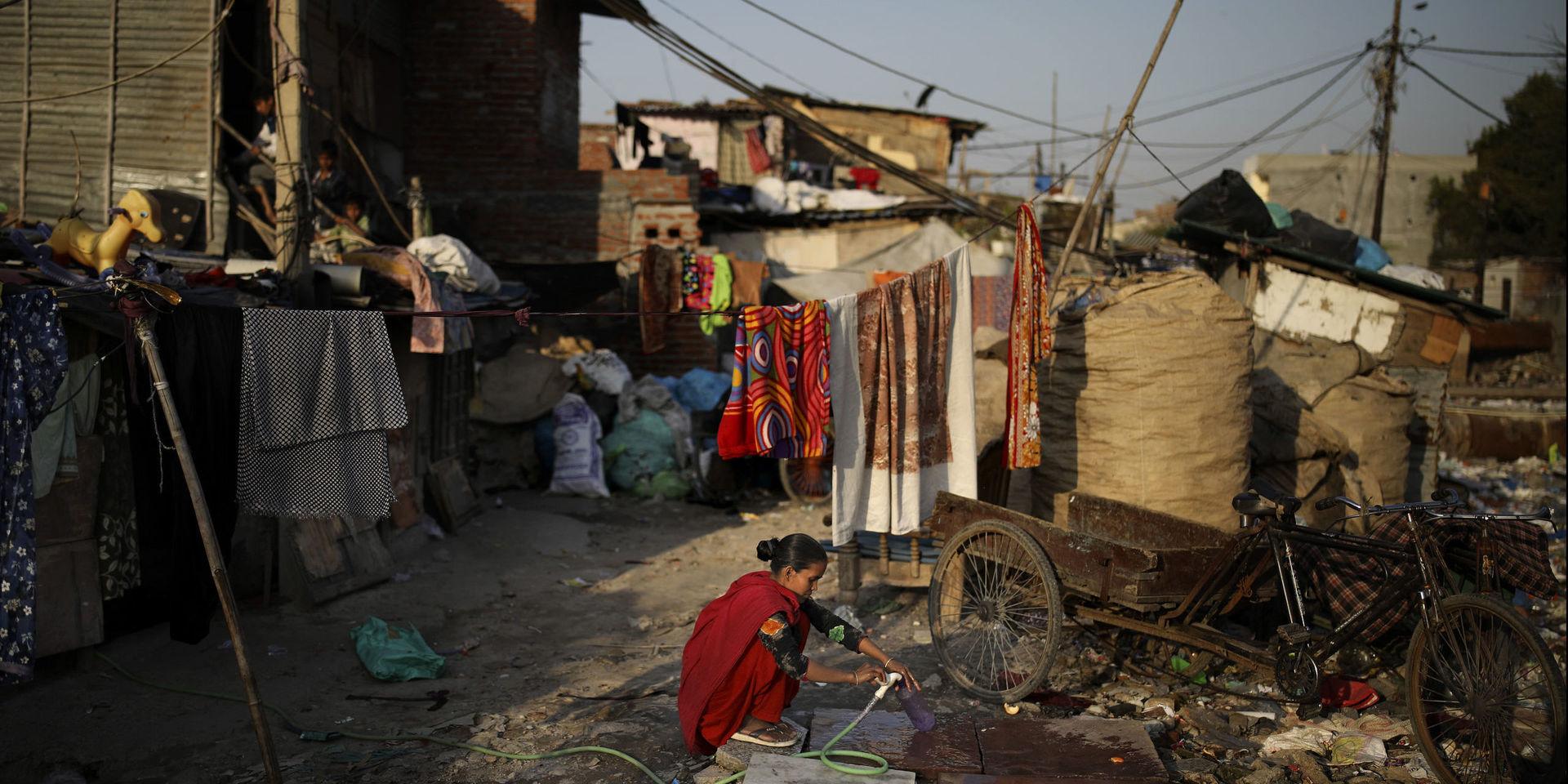 En kvinna hämtar vatten i ett av den indiska huvudstaden Delhis slumområden. Bristen på rinnande vatten i världens kåkstäder förväntas förvärra smittspridningen allvarligt.