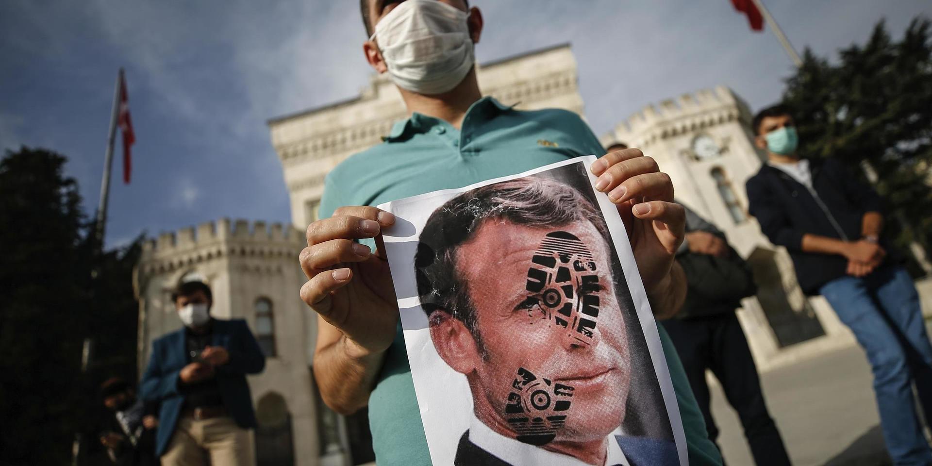 En ung man protesterar mot Frankrikes president Emmanuel Macron vid en demonstration i Istanbul.