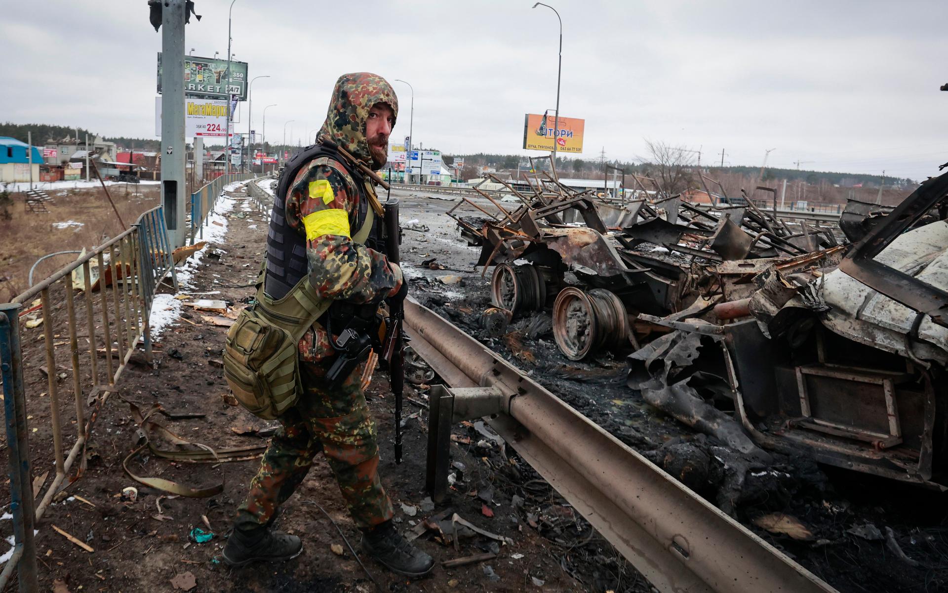 En beväpnad man i Bucha. Tidigt på onsdagsmorgonen uppger den ukrainska militären att ryska styrkor via luften har tagit sig in i landets näst största stad Charkiv.