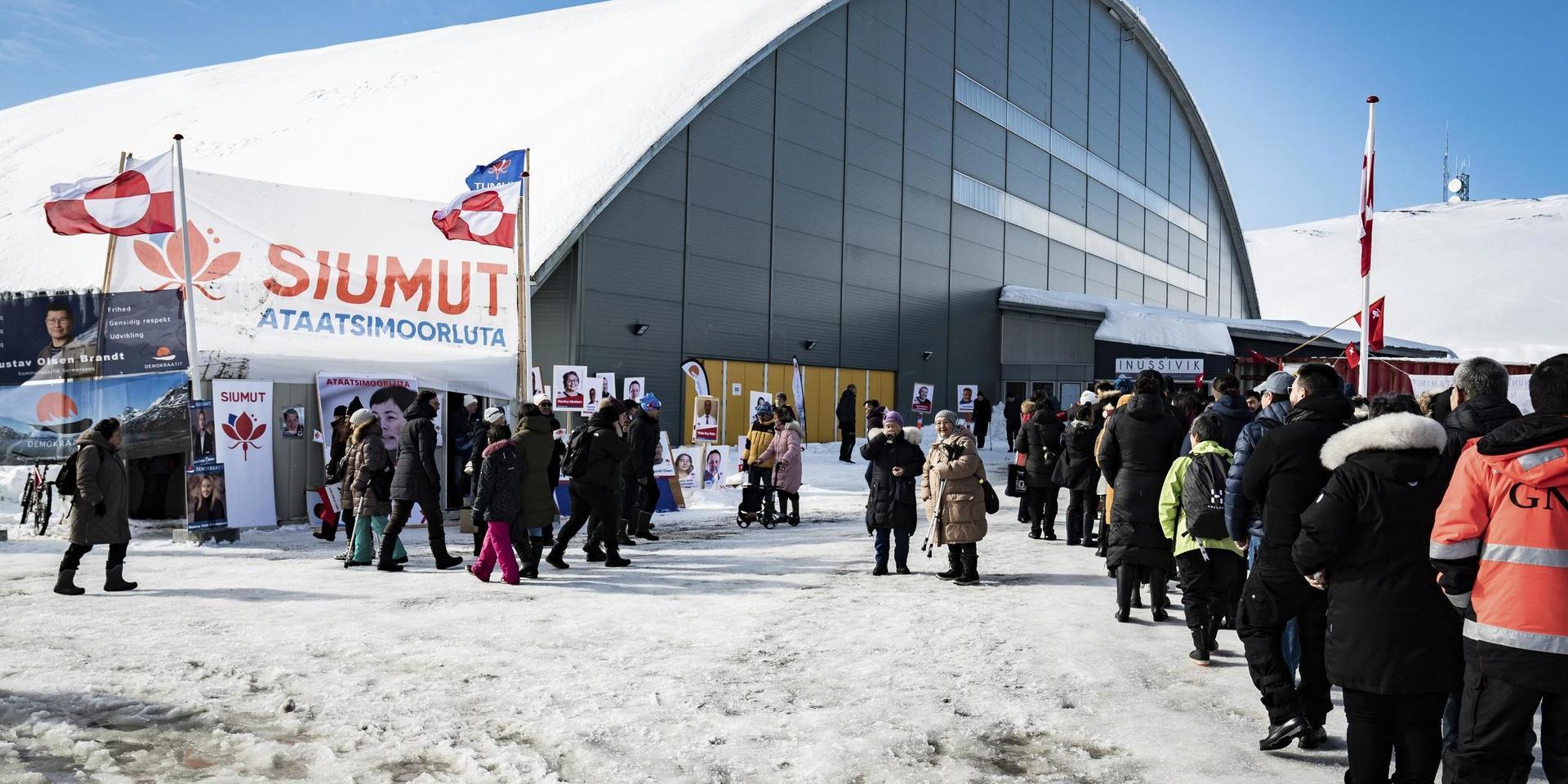 Människor köar utanför Inussivik arena i Nuuk, en av vallokalerna under tisdagens parlamentsval på Grönland.