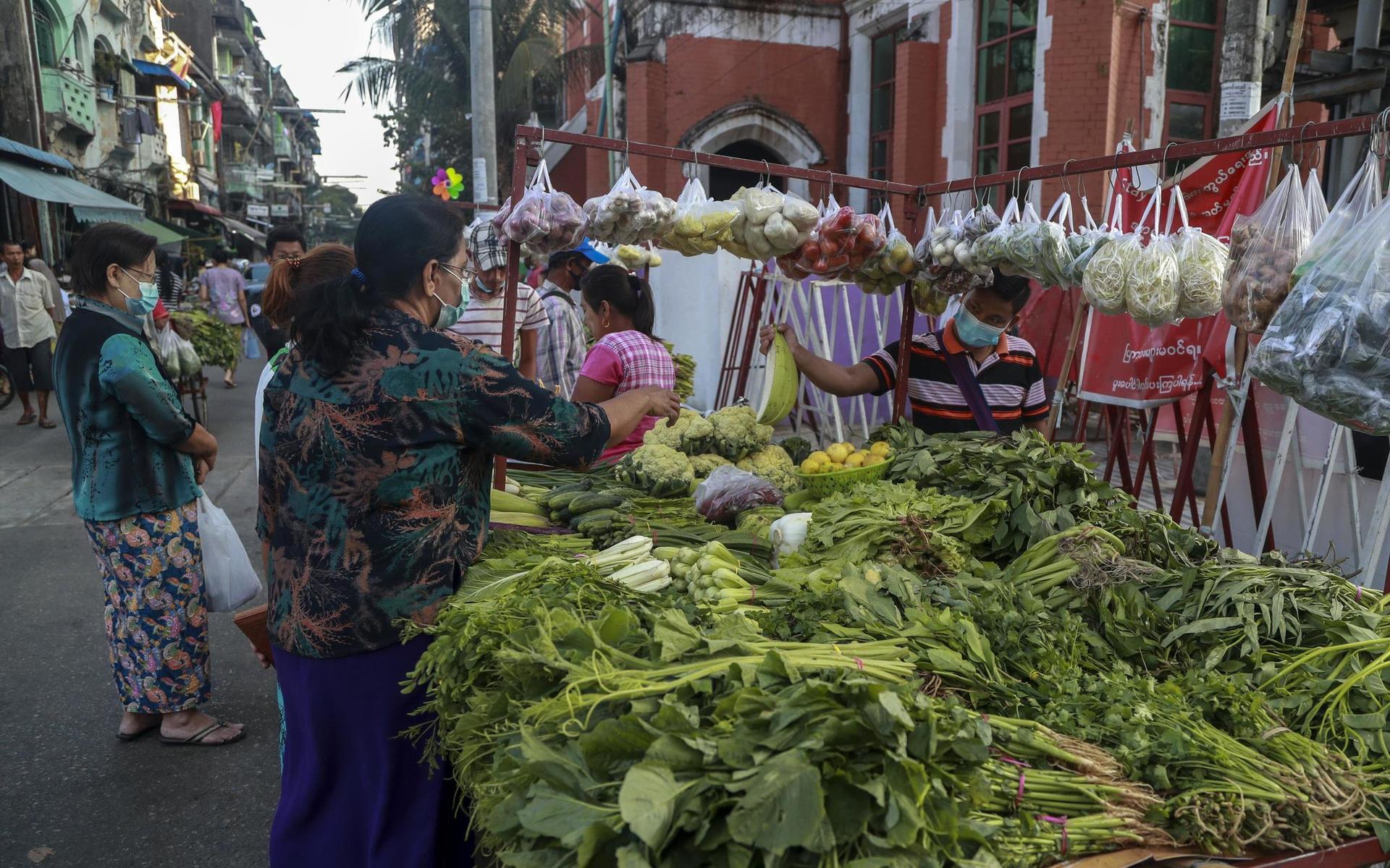 A woman buys vegetable in a street market Yangon, Myanmar, Tuesday, Feb. 2, 2021. Hundreds of members of Myanmar&apos;s Parliament remained confined inside their government housing in the country&apos;s capital on Tuesday, a day after the military staged a coup and detained senior politicians including Nobel laureate and de facto leader Aung San Suu Kyi. (AP Photo/Thein Zaw)  XGA111