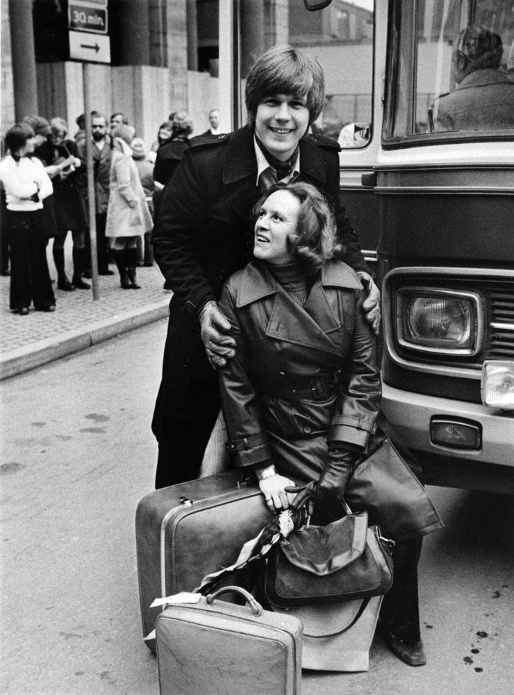 Operasångarna Håkan Hagegård och Kerstin Meyer står med sin packning utanför bussen på Gustav Adolfs Torg i Stockholm 29 januari 1975 för avresa med Kungliga Operan till Hongkong. Arkivbild.