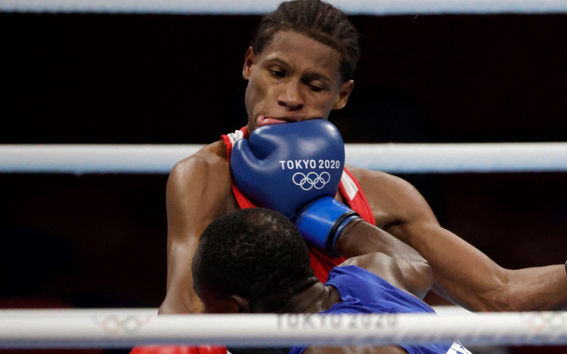 Ghanas Sulemanu Tetteh åker på en praktträff mot Rodrigo Marte från den Dominikanska Republiken i OS-boxningen.