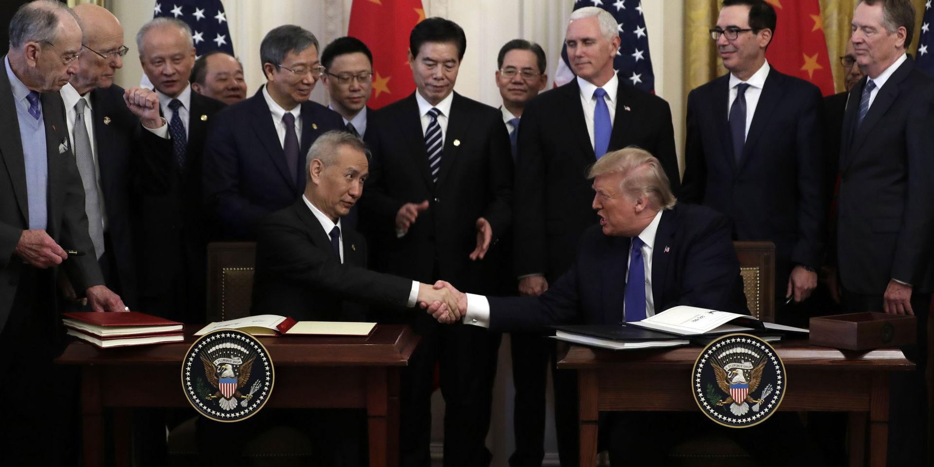 Kinas vice premiärminister Liu He och USA:s president Donald Trump skakar hand efter att ha undertecknat det partiella handelsavtalet. Ceremonin skedde i Vita huset i Washington.