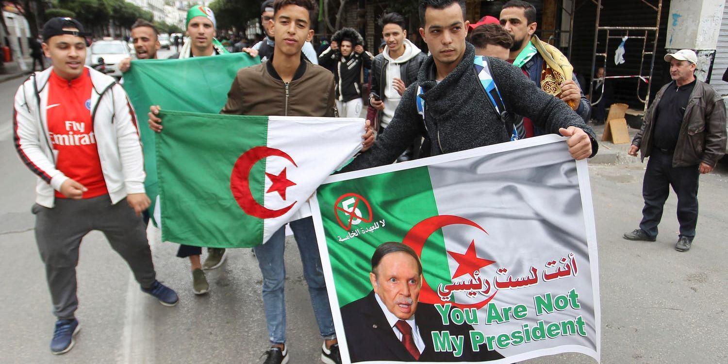 Unga demonstranter med bilder på president Abdelaziz Bouteflika och algeriska flaggor i Alger på fredagen.