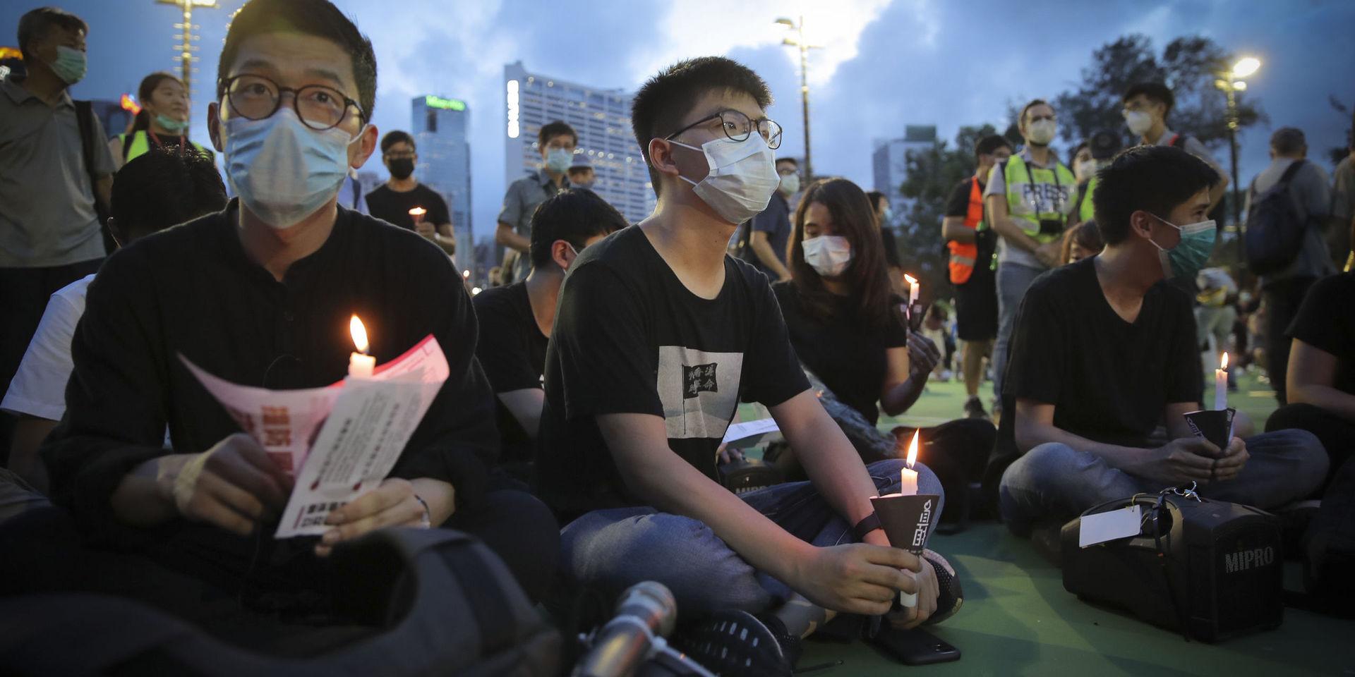 Den framträdande demokratiaktivisten Joshua Wong (mitten) är en av de som samlats för ljusmanifestationen för massakern på Himmelska fridens torg. 
