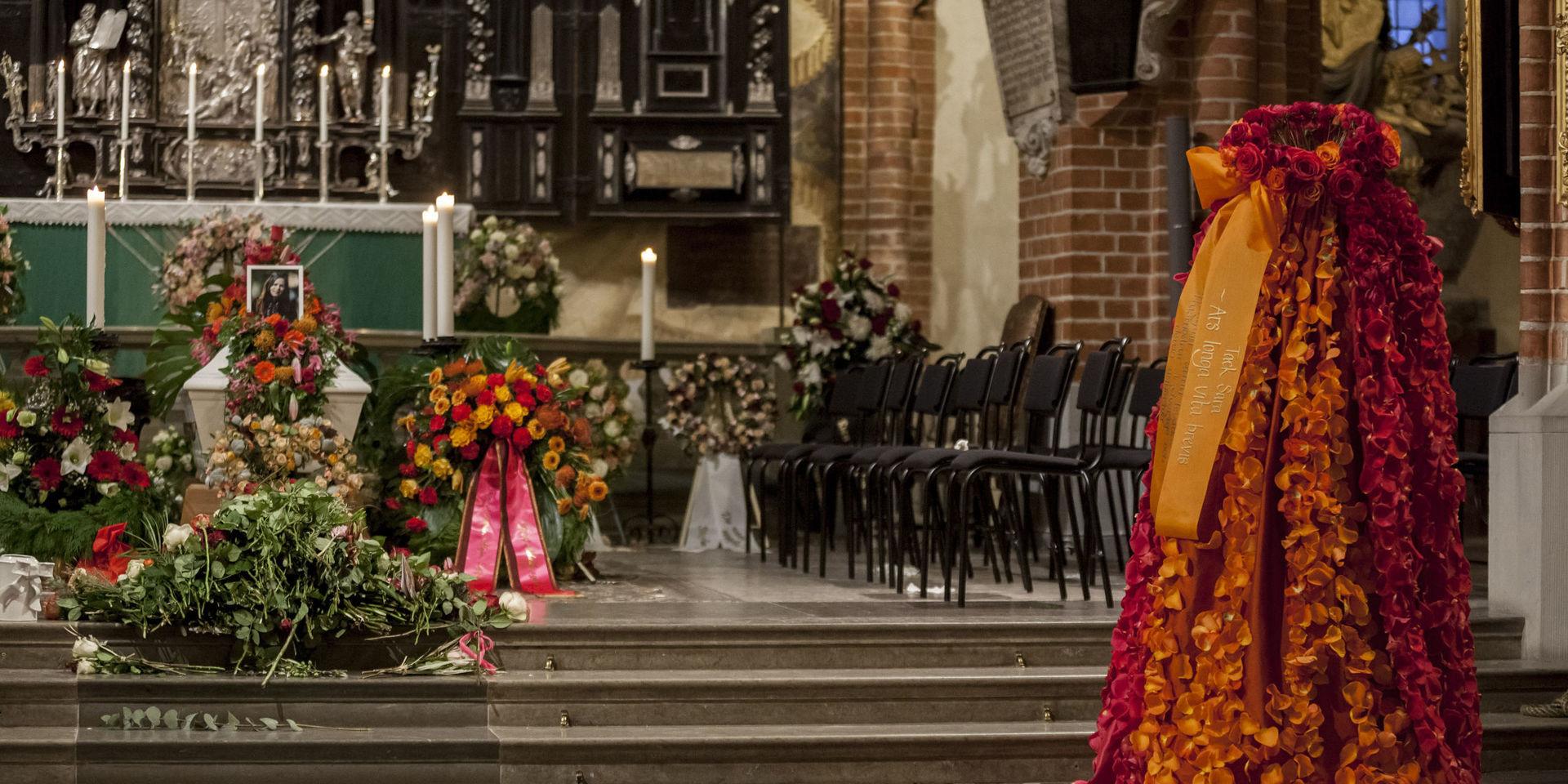 Ett blomsterarrangemang som liknade klänningen Sara Danius bar vid fjolårets Nobelpristutdelning fanns uppställt framme i kyrkan vid hennes begravning 8 november. Pressbild. 
