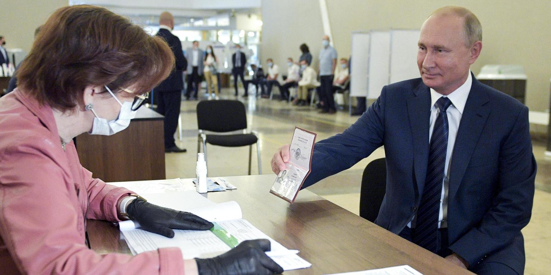 President Putin visar upp sitt pass för att lägga sin röst i en vallokal i Moskva. Om lagförslaget går igenom kan Putin i teorin sitta kvar vid makten till år 2036.