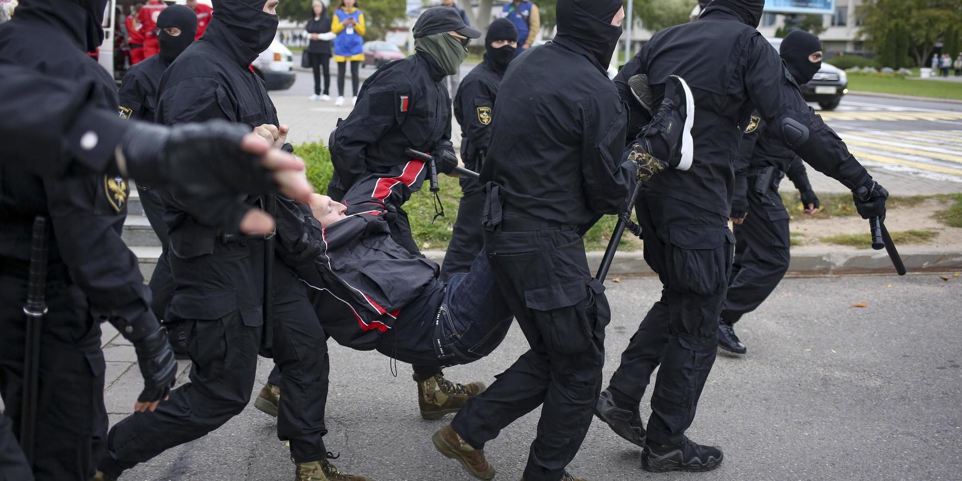 Polisen i Belarus griper en demonstrant i Minsk under söndagens massprotest. 