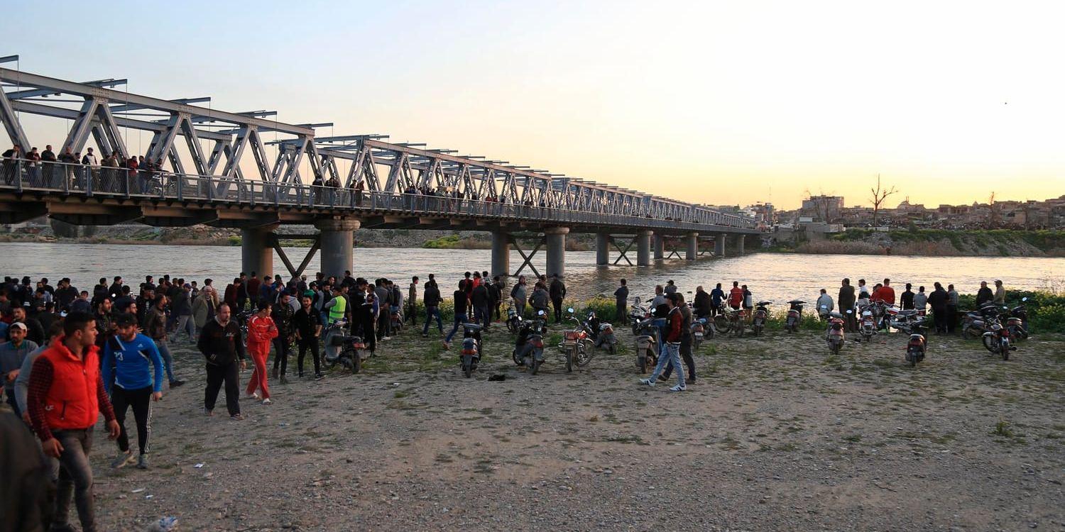 Invånare och anhöriga samlas vid Tigris i Mosul efter den färjeolycka som krävde nästan 100 liv.