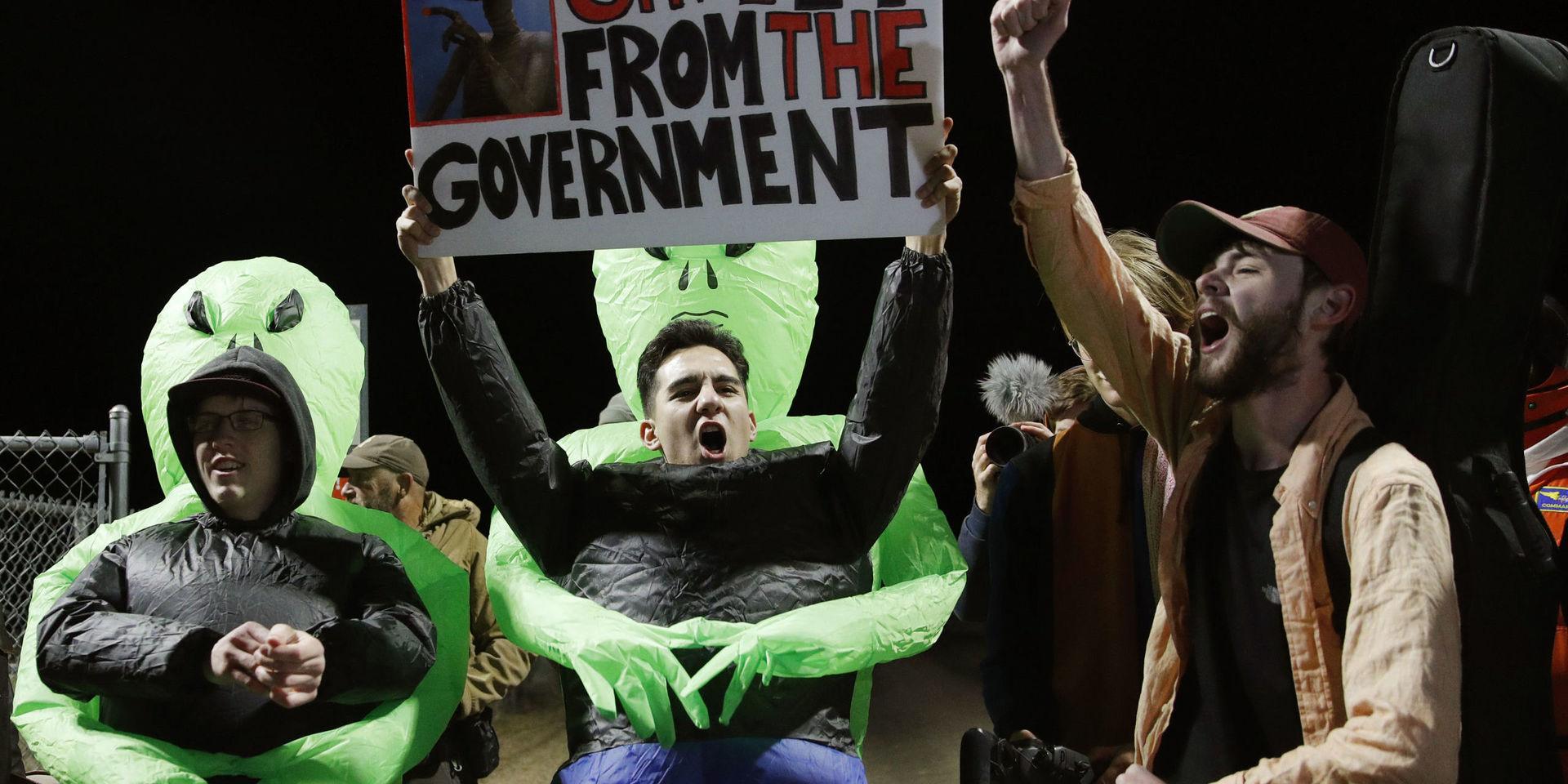 'Rädda ET från regeringen', har människor skrivit på plakat utanför Area 51.
