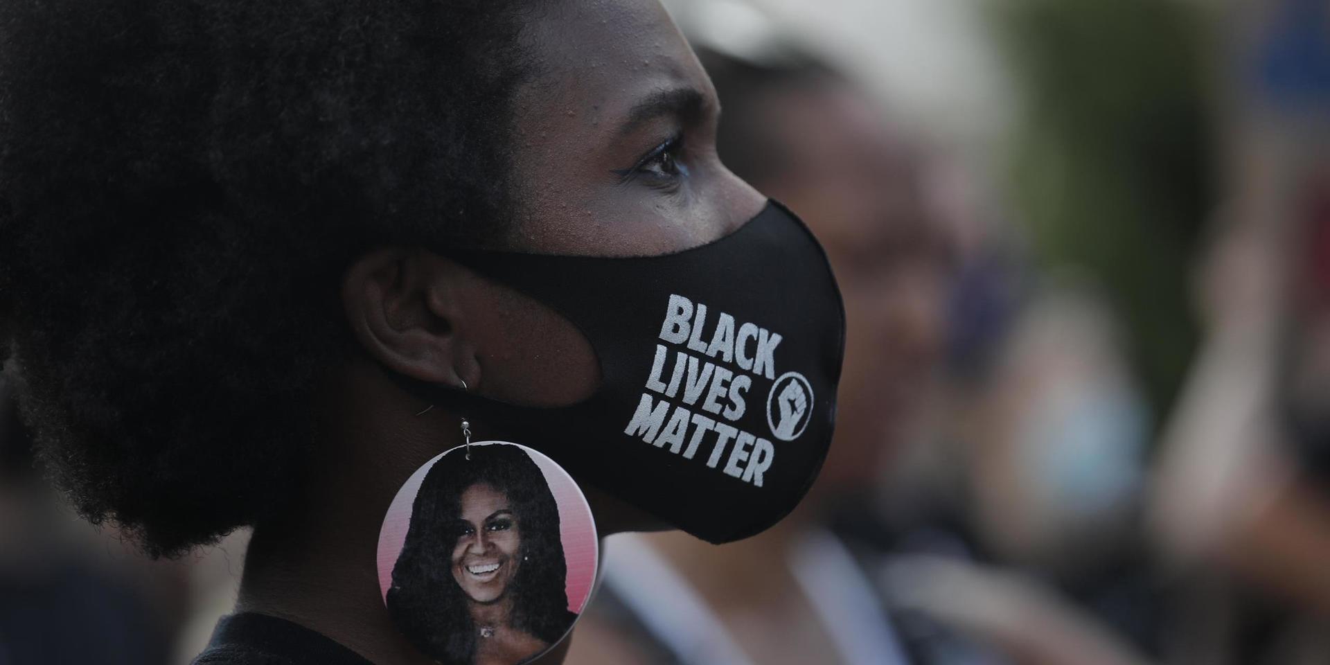 En demonstrant med den forna första damen Michelle Obama på örhänget under lördagen i Washington.