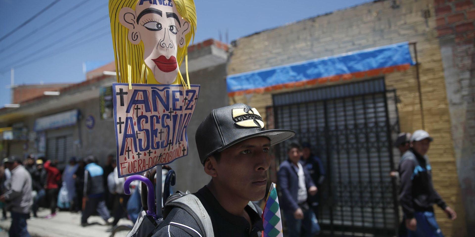 En anhängare till den tidigare presidenten Evo Morales håller ett plakat med texten 'Jeanine Áñez lönnmördare, försvinn' under en demonstration i El Alto utanför huvudstaden La Paz.