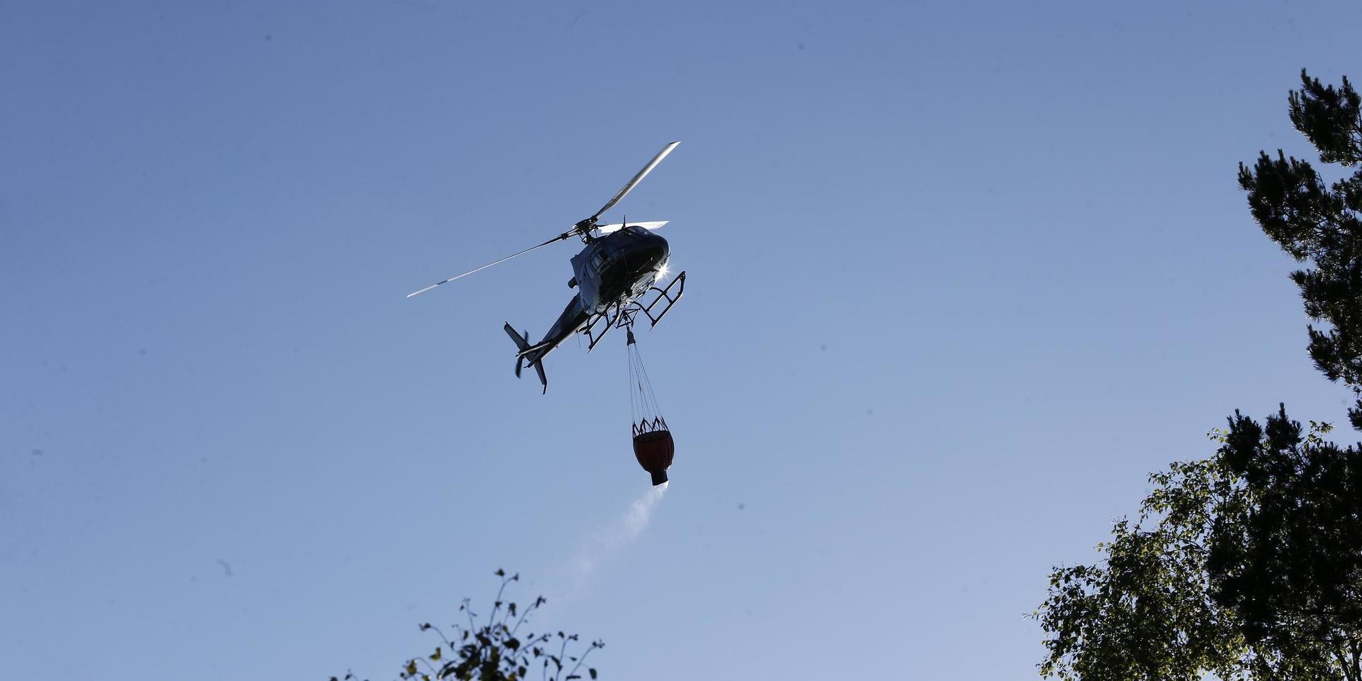 Helikopter som vattenbombar branden i Vrinneviskogen.