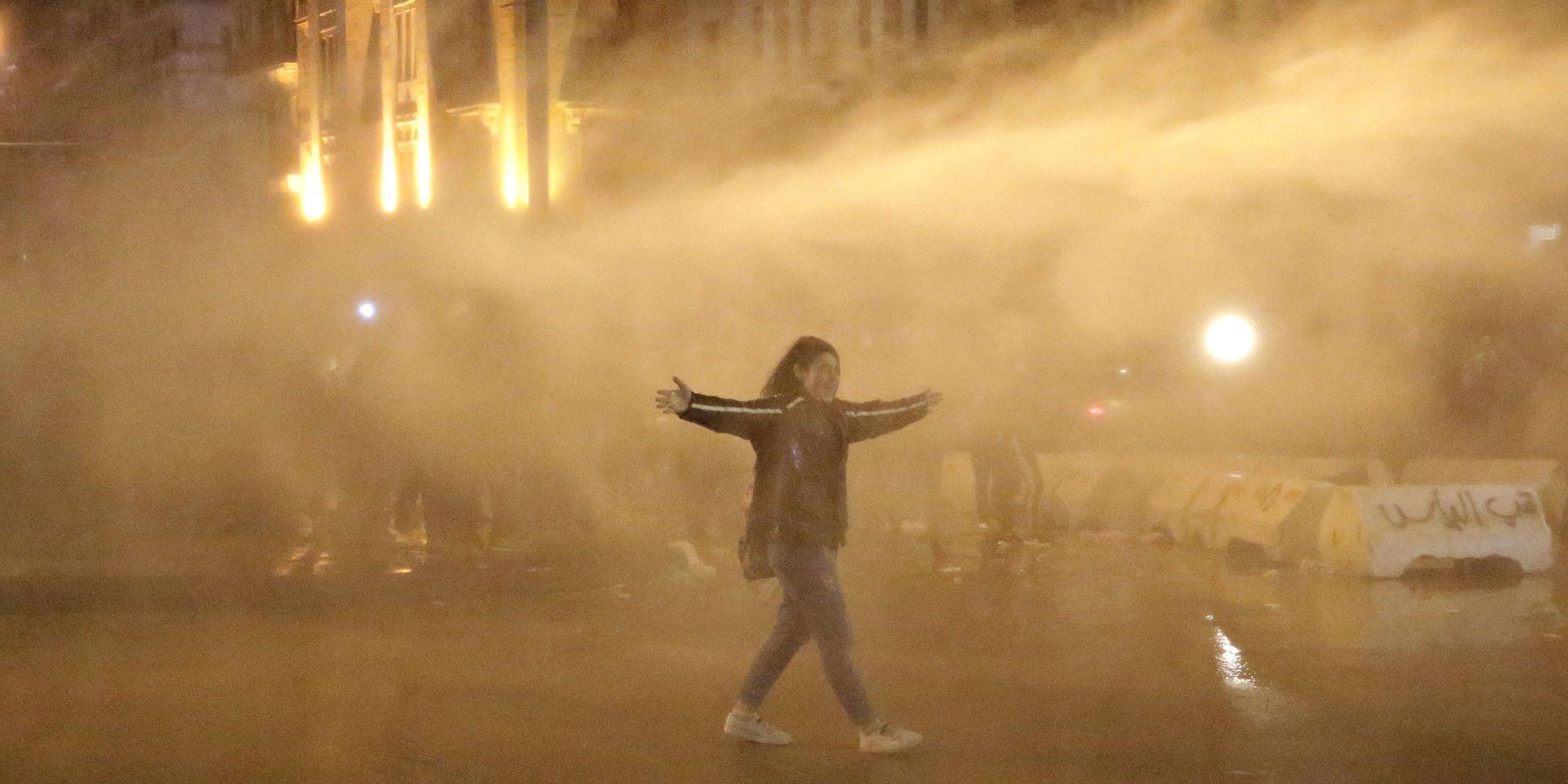 En demonstrant sprejas av vattenkanoner i helgens protester i Beirut.
