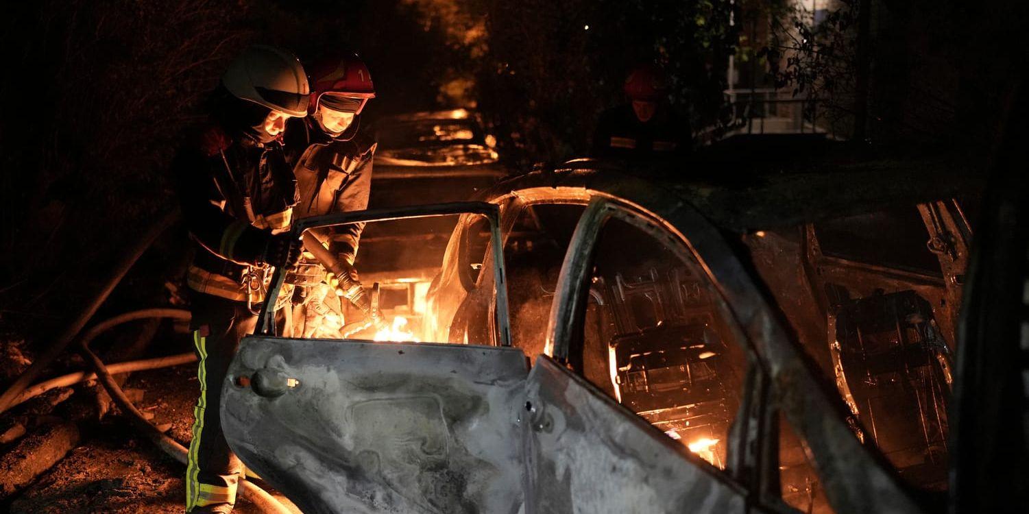 Räddningstjänsten i Kiev släcker en brand som brutit ut i ett fordon under nattens ryska attack mot huvudstaden.
