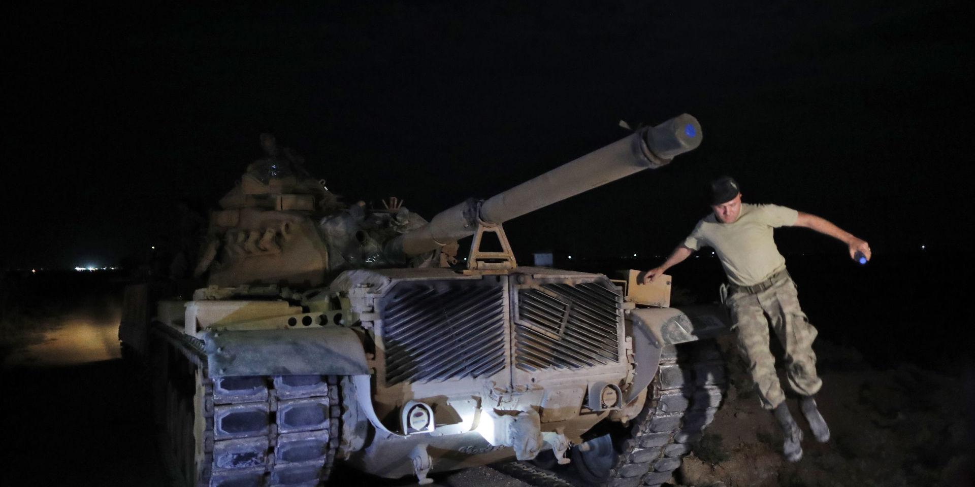 En turkisk arméofficer hoppar ner från en stridsvagn vid gränsen mellan Turkiet och Syrien. 