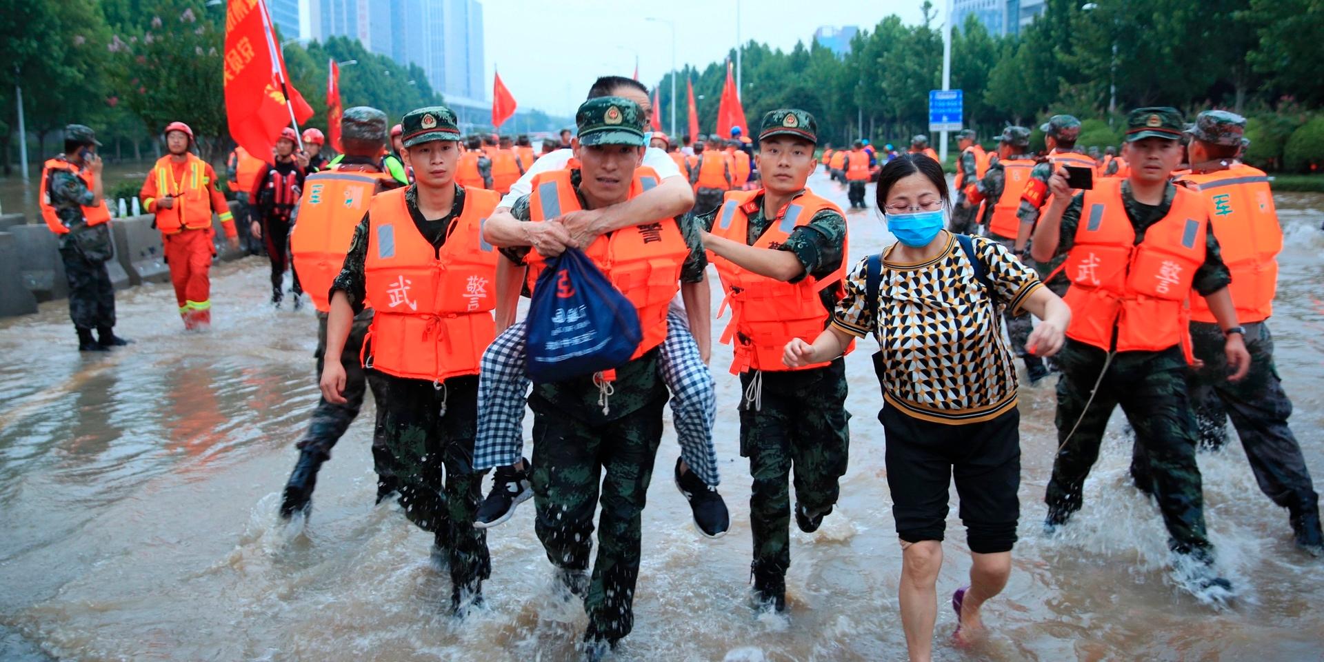 Kinesisk militär evakuerar invånare i samband med översvämningarna i staden Zhengzhou.