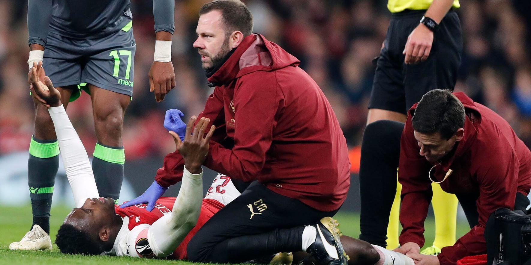 Arsenals Danny Welbeck får vård efter fotledsskadan i Europa League-matchen mot Sporting Lissabon.