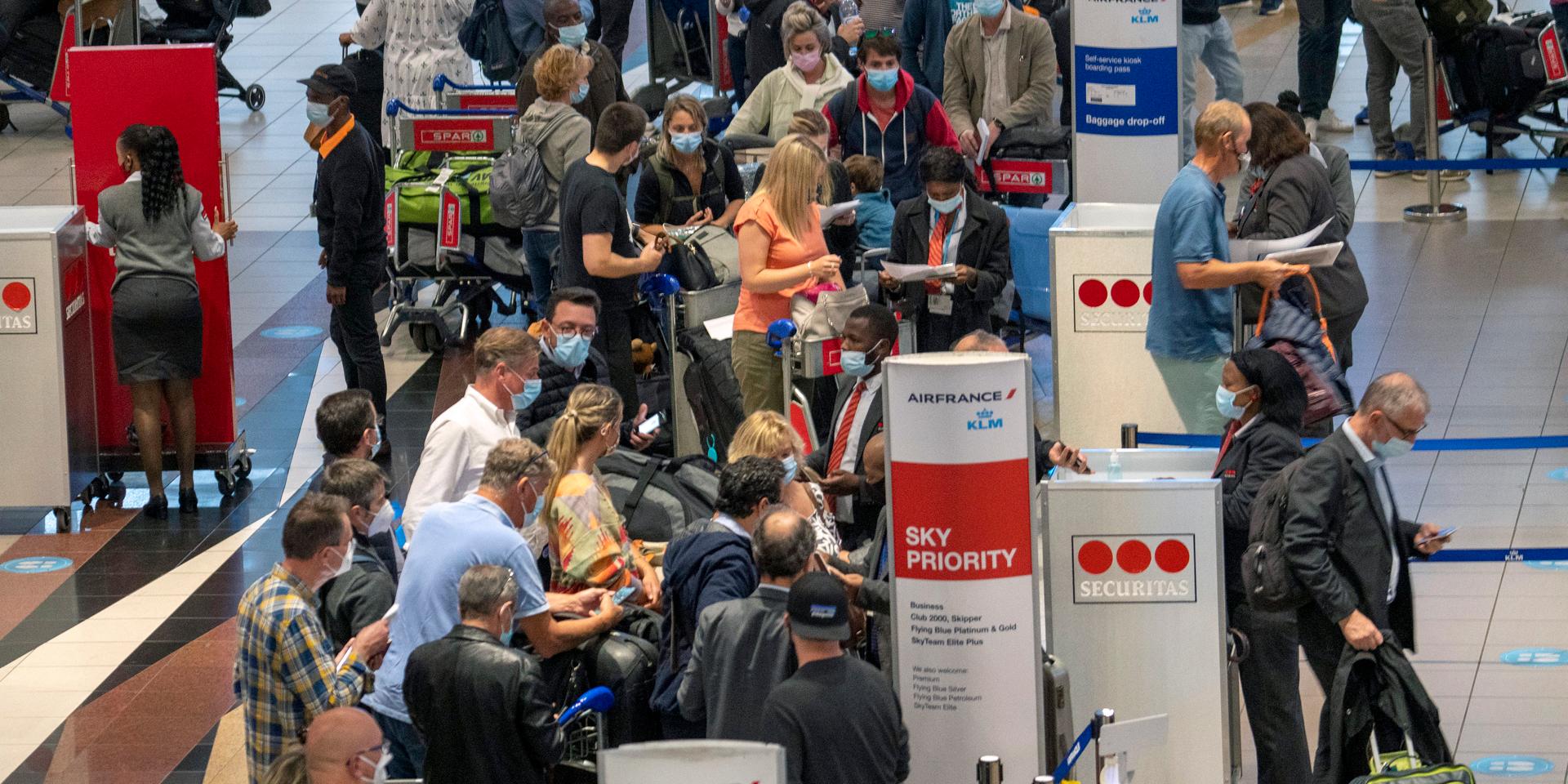 Långa köer på Johannesburgs internationella flygplats efter att larmet om den nya virusvarianten fått många länder att införa flygstopp för resenärer från Sydafrika.