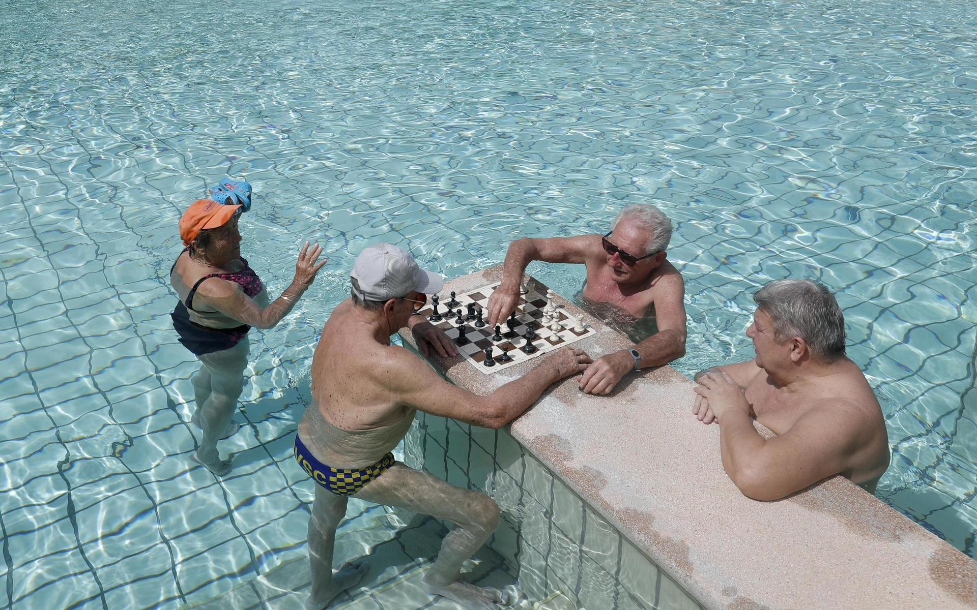 Äldre herrar spelar schack på det nyligen återöppnade Szechenyi-badet i Budapest, Ungern.