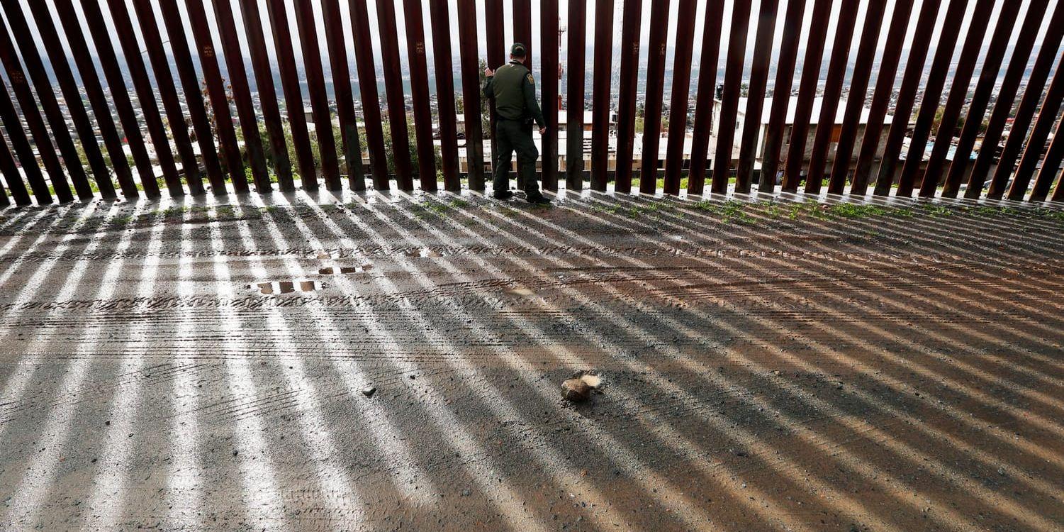 En gränsvakt vid en del av den gränsbarriär som separerar mexikanska Tijuana från amerikanska San Diego.