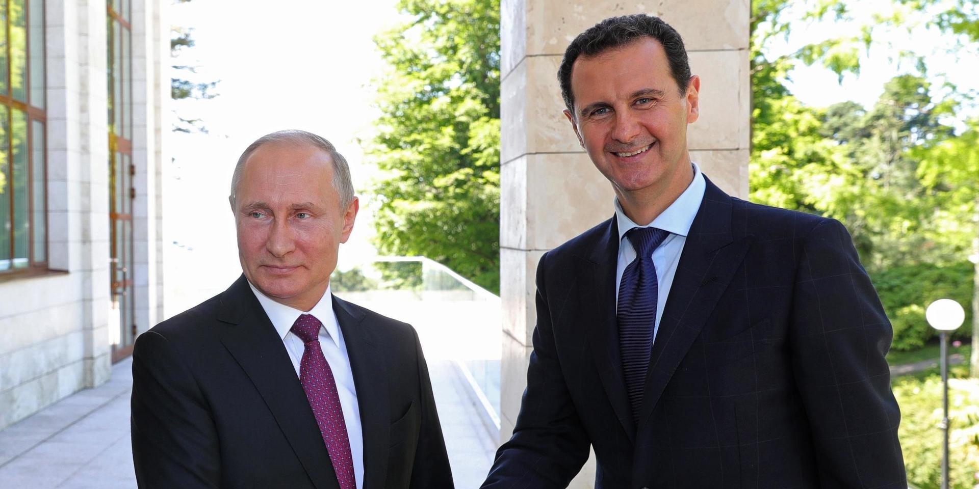 FILE - In this May 17, 2018, file photo, Russian President Vladimir Putin, left, shakes hands with Syrian President Bashar al-Assad during their meeting in the Black Sea resort of Sochi, Russia. Assad is the last man standing among a crop of Arab dictators after the fall of the Sudanese and Algerian leaders. He's survived an 8-year war to topple him and an Islamic caliphate over part of his broken country. But Bashar Assad's path is strewn with difficulties and the war for Syria is far from over. (Mikhail Klimentyev, Sputnik, Kremlin Pool Photo via AP, File)