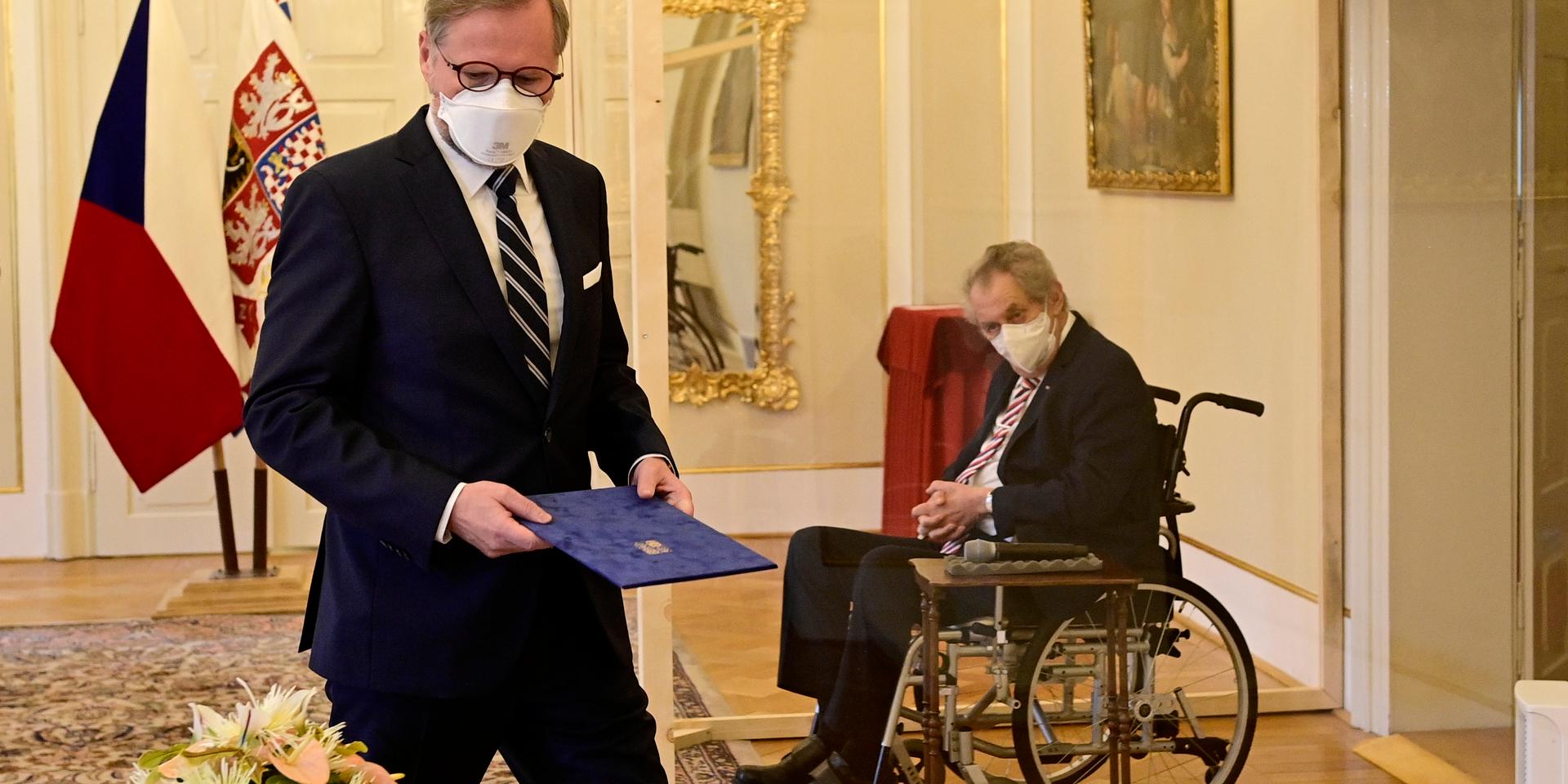 President Milos Zeman satt i rullstol bakom plexiglas vid ceremonin.