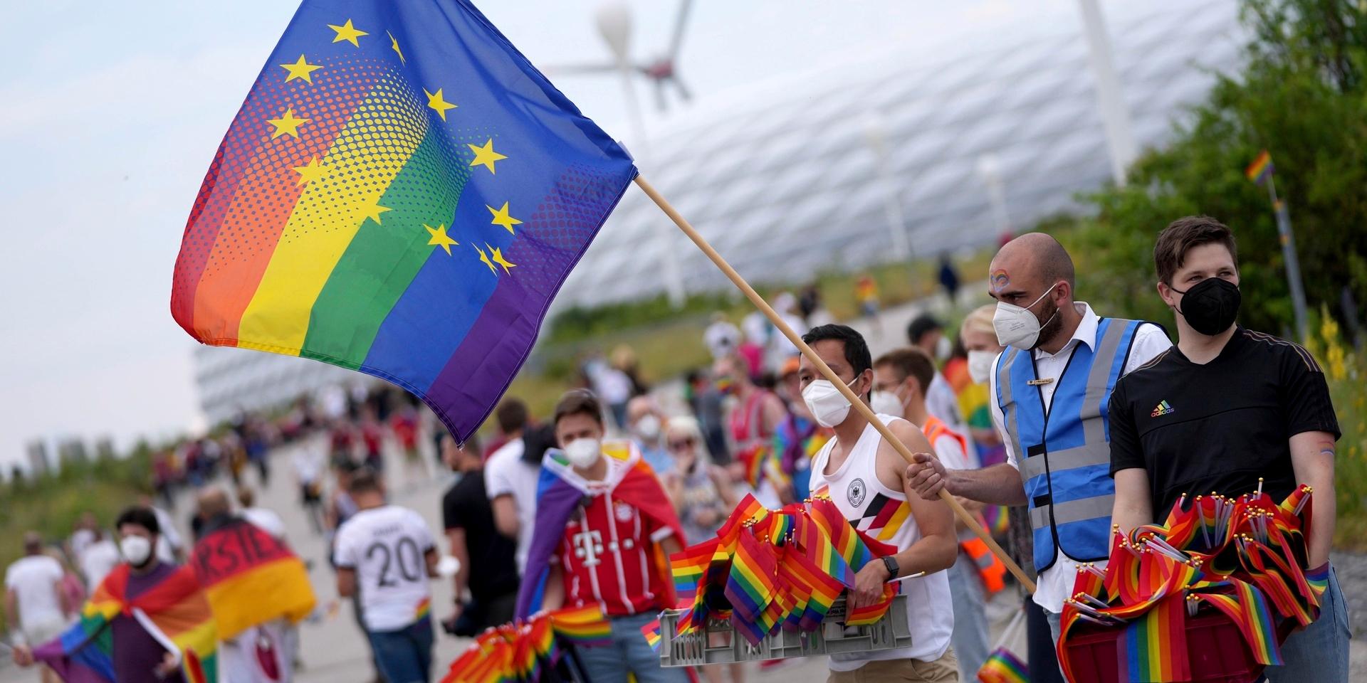 Football supporters are seen with LGBT pride flags outside of the stadium before the Euro 2020 soccer championship group F match between Germany and Hungary at the Allianz Arena in Munich, Germany,Wednesday, June 23, 2021. (AP Photo/Matthias Schrader)  FAS106