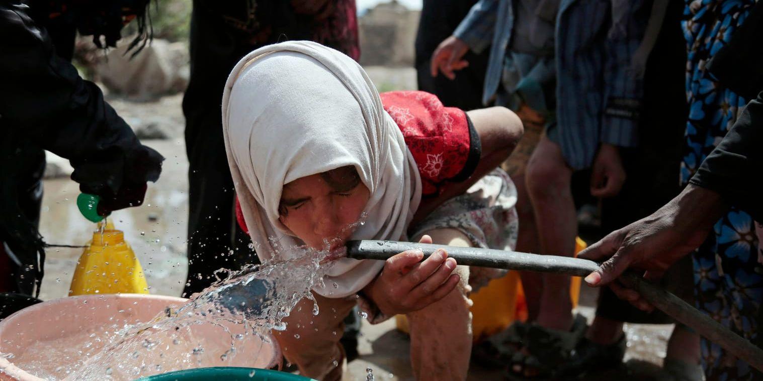 En flicka dricker vatten från en brunn i Jemens huvudstad Sanaa. Arkivbild.