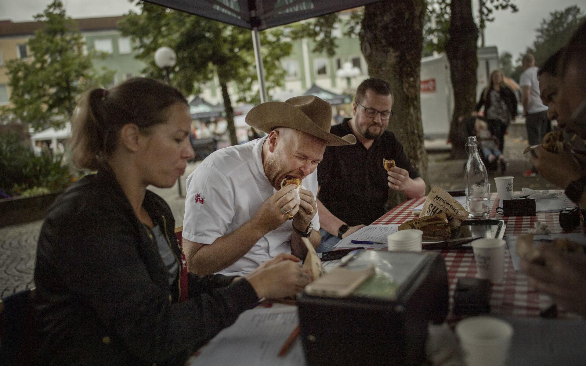 På bettet. Jurymedlemmen Johan Jureskog smakar på en av de tävlade hamburgarna. Vid sin sida har han jurykollegorna Sara Kullberg och Nils Thuresson.