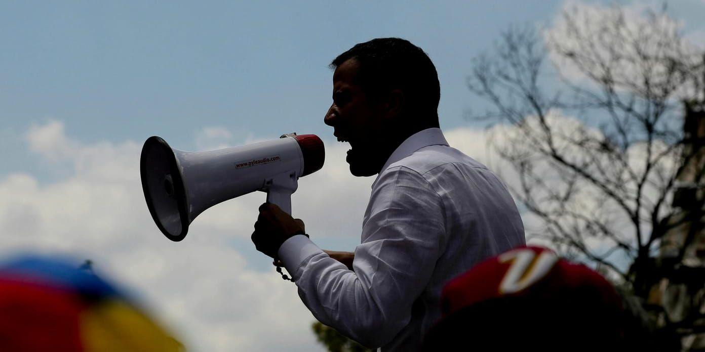 Venezuelas oppositionsledare Juan Guaidó talade i en megafon under demonstrationen i Caracas.
