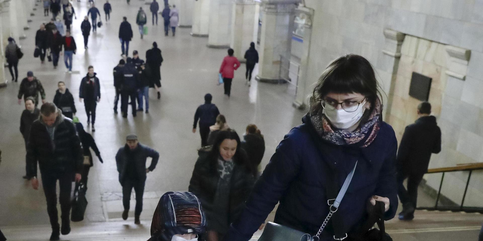 A woman with her child wear medical masks walk inside the Komsomolskaya Metro (subway) station in Moscow, Russia, Wednesday, March 18, 2020. Authorities in Russia are taking vast measures to prevent the spread of the disease in the country. The measures include closing the border for all foreigners, shutting down schools for three weeks, sweeping testing and urging people to stay home. For most people, the new coronavirus causes only mild or moderate symptoms. For some it can cause more severe illness. (AP Photo/Pavel Golovkin)  XAZ112