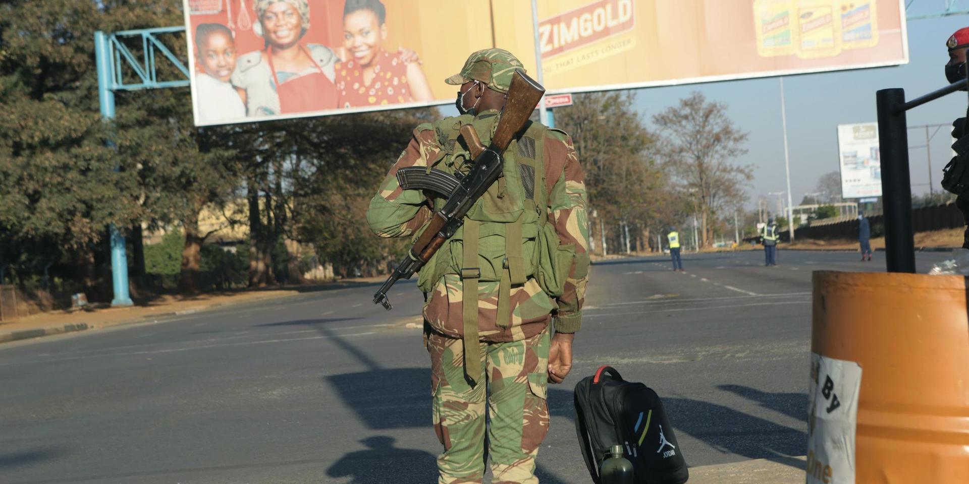 En soldat bevakar en folktom gata i Harare på fredagen.