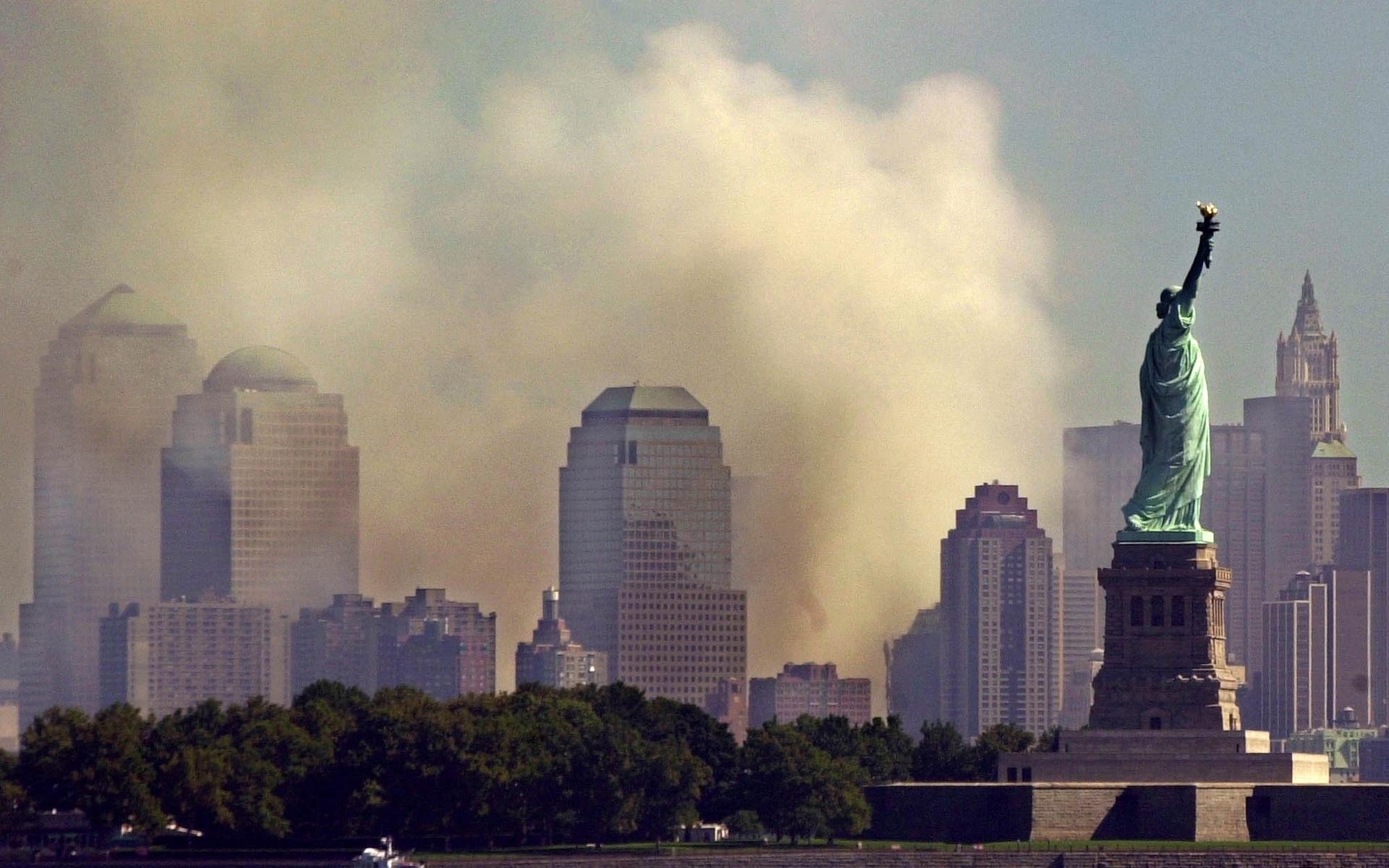 With the Statue of Liberty standing in New York Harbor, smoke rises from lower Manhattan following the destruction of buildings at the World Trade Center in New York, Wednesday Sept. 12, 2001.  Two hijacked commercial aircraft crashed into the center&apos;s towers. (AP Photo/Charles Krupa)