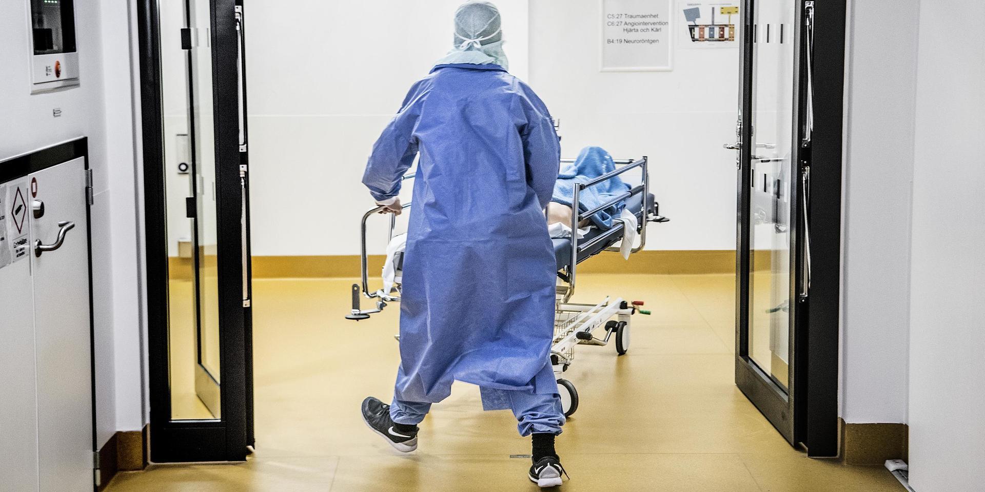 En patient rullas iväg i en sjukhussäng.