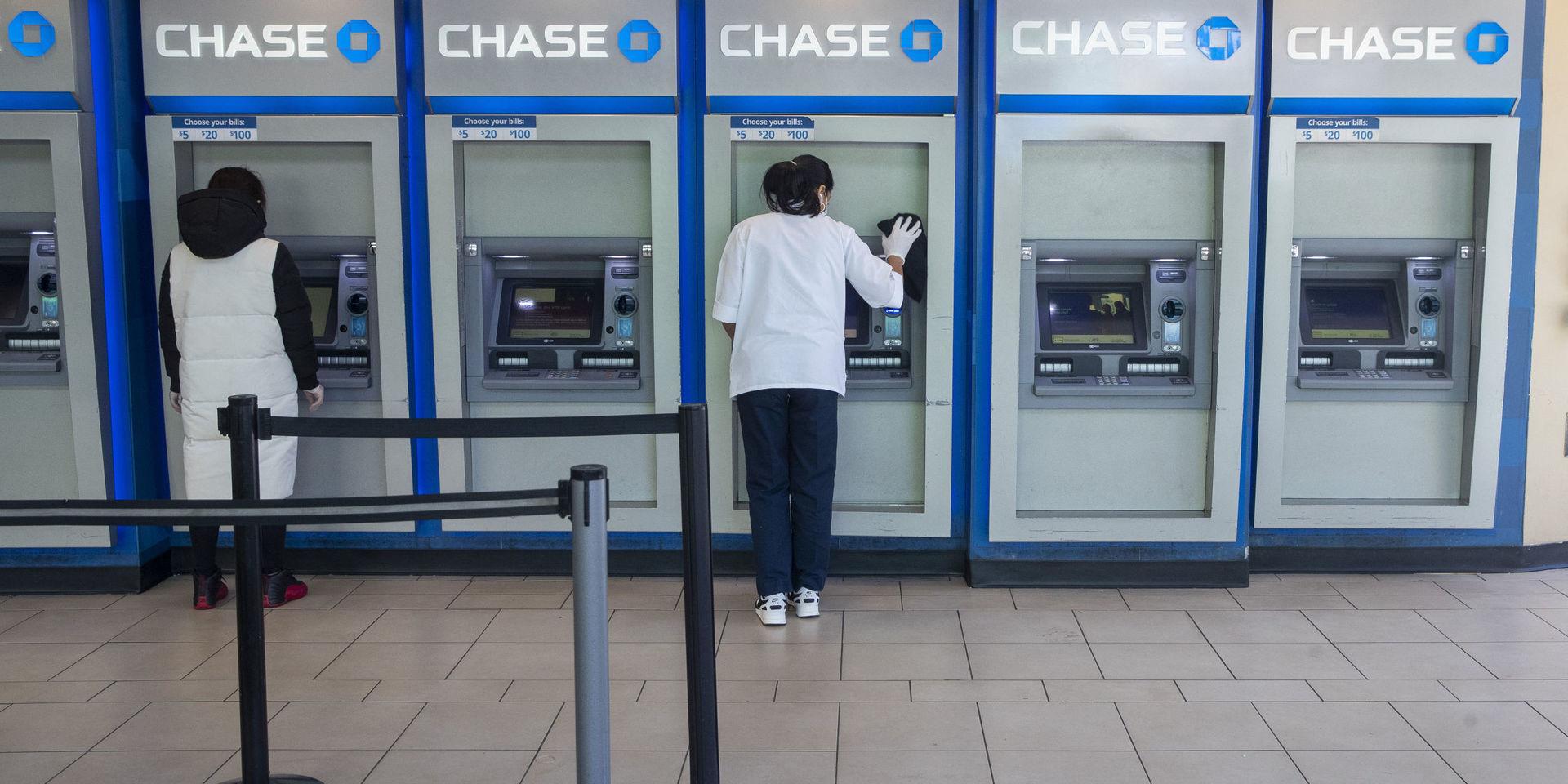 En bankanställd desinficerar bankomater i Queens. 