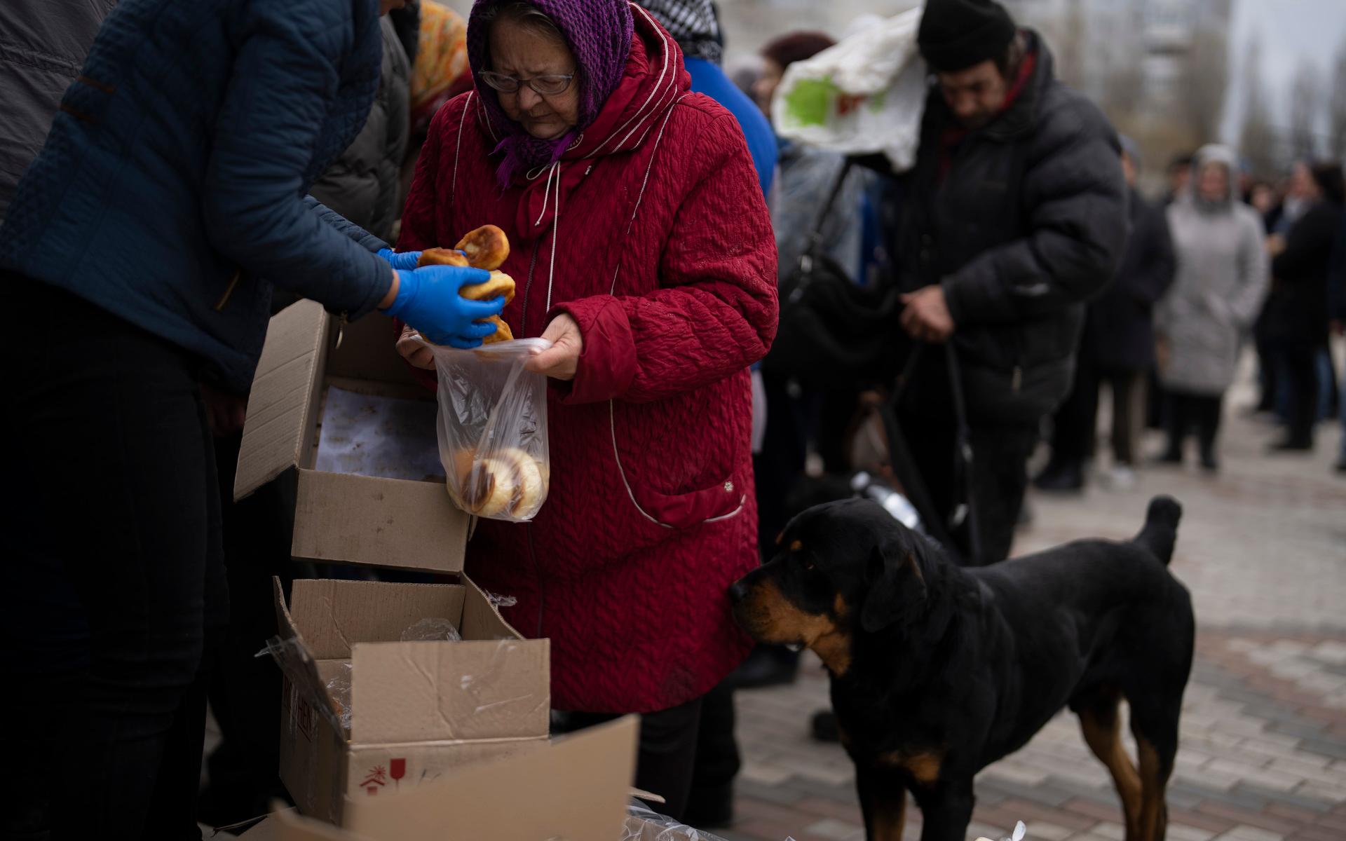 People receive food from a church in the town of Borodyanka, about 40 miles northwest of Kyiv, Ukraine, on Sunday, April 10, 2022. Several apartment buildings were destroyed during fighting between the Russian troops and the Ukrainian forces and the town is without electricity, water and heating. (AP Photo/Petros Giannakouris)  XPG108
